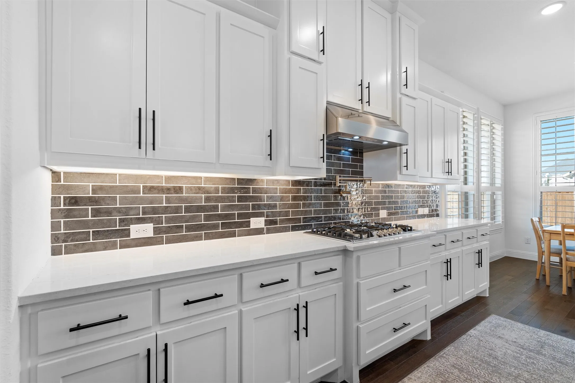 Those crisp white cabinets against the textured backsplash! ?? Talk about a clean and modern kitchen look. Who else is obsessed? ?????????? #WhiteKitchen #ModernDesign #KitchenInspo