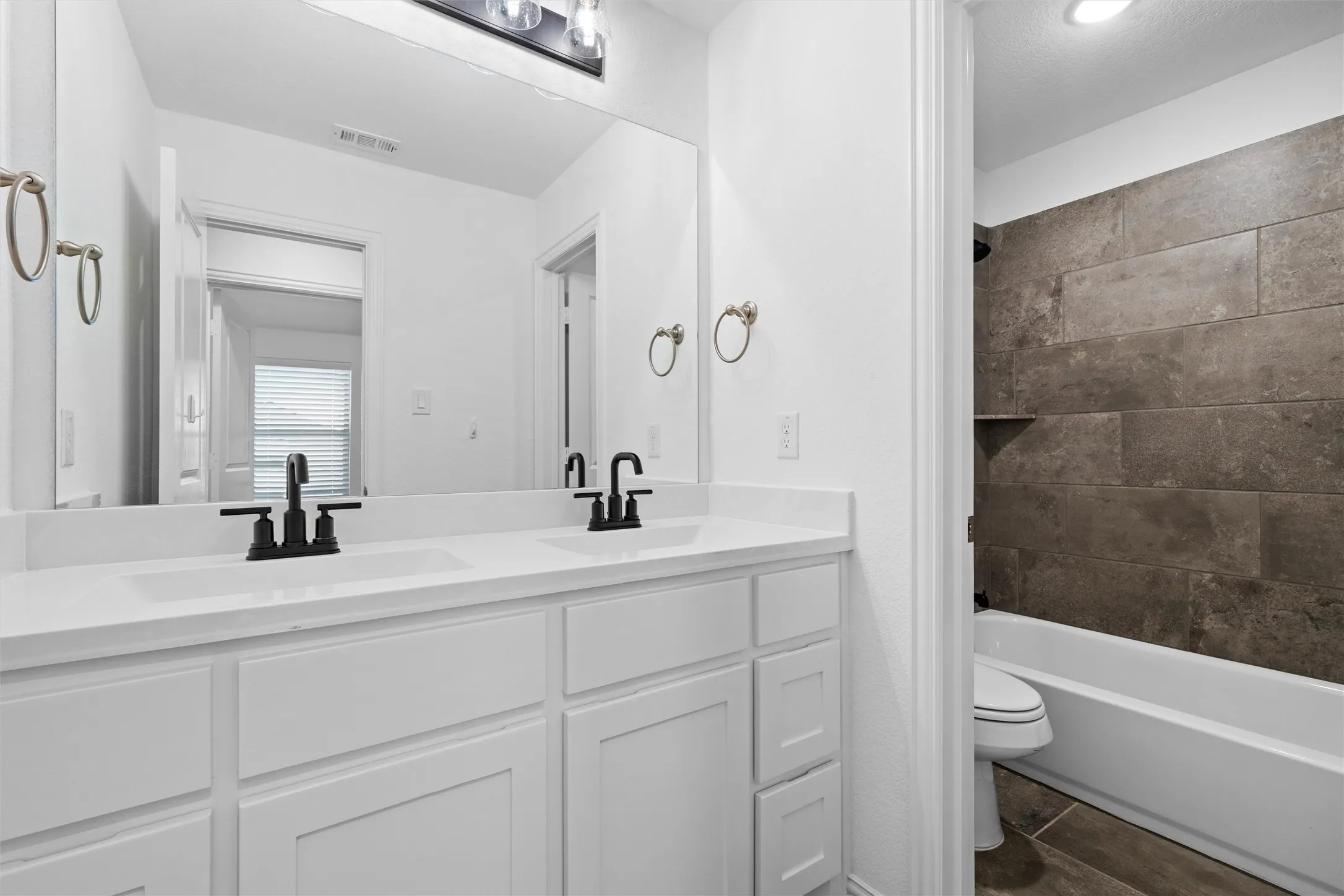 Spa vibes unlocked! ?? Double sinks with chic black fixtures paired with that gorgeous dark accent tile in the tub surround... absolute perfection! ???? #BathroomGoals #ModernDesign #HomeSpa