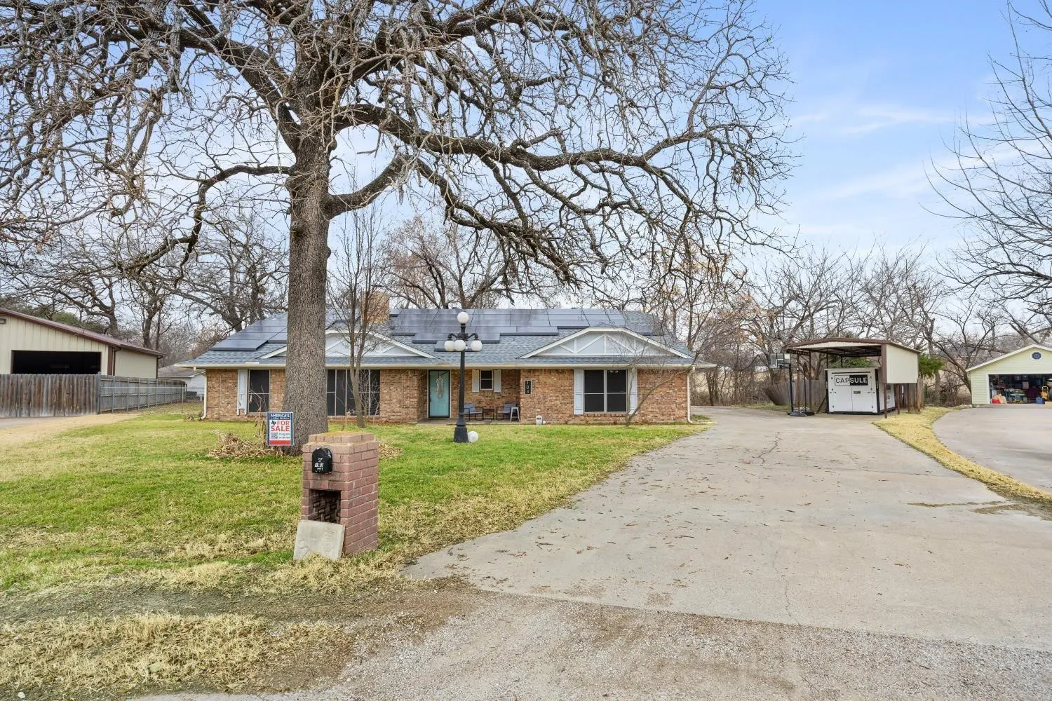 Charming brick residence situated on expansive grounds featuring mature oak trees