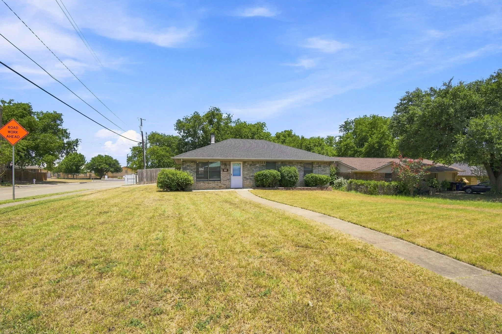 Full front view of the home set on a spacious lot with mature landscaping and great curb appeal.