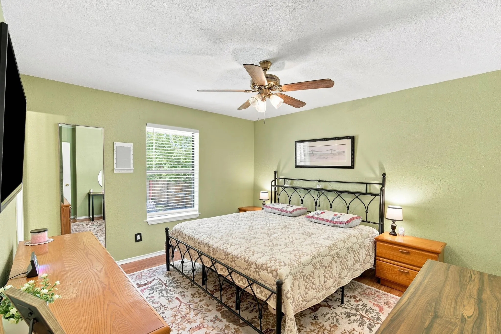 Comfortable bedroom with soft green walls and convenient closet access.
