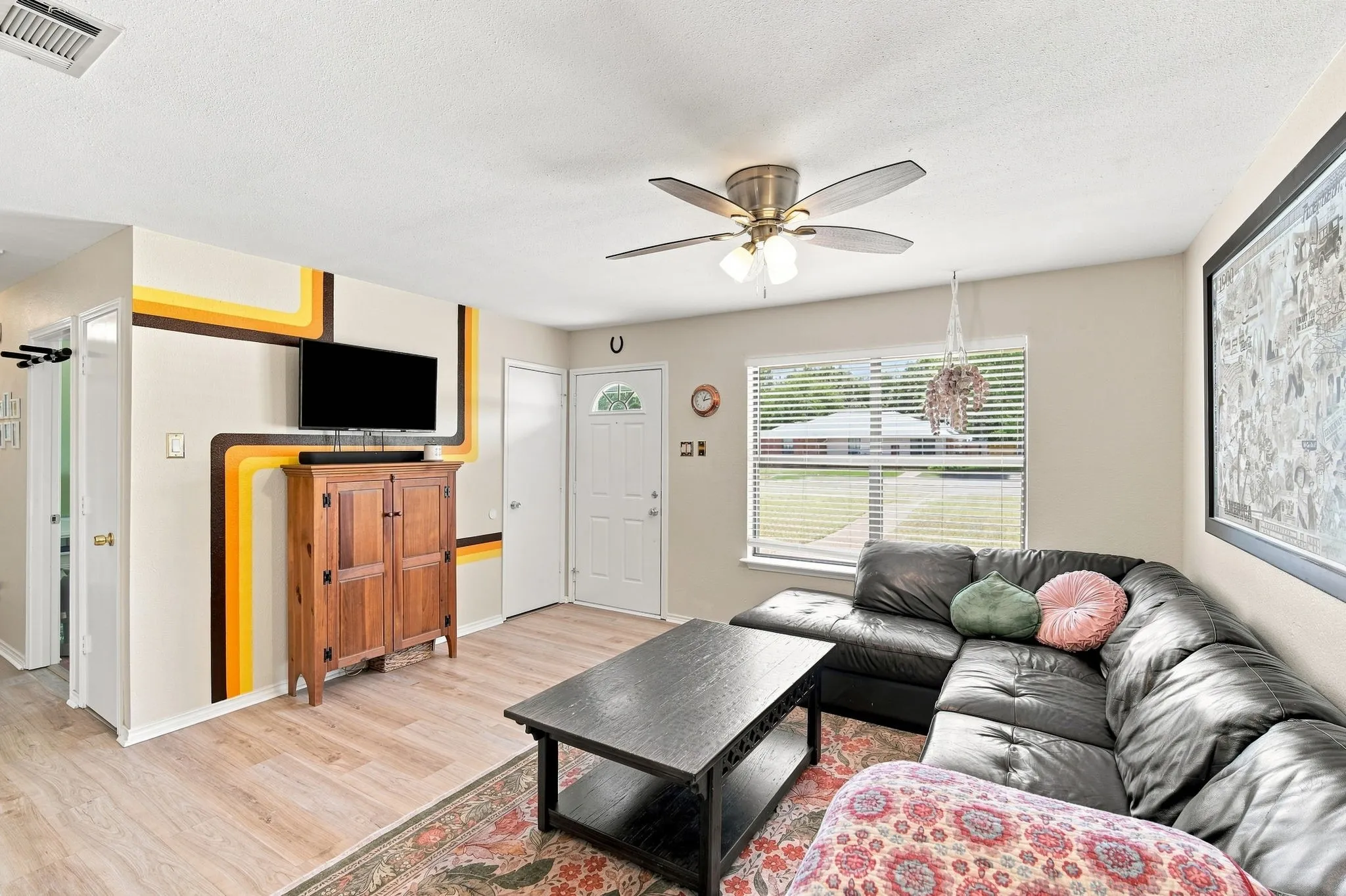 Open living area with wood-look flooring and a lovely view toward the front entry.