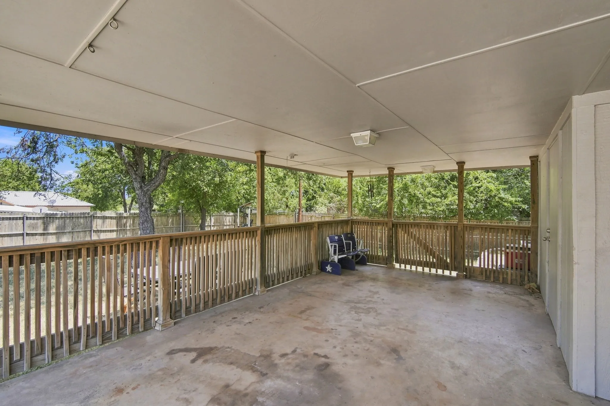 Covered patio with wood railing, a shaded retreat to enjoy the outdoors.
