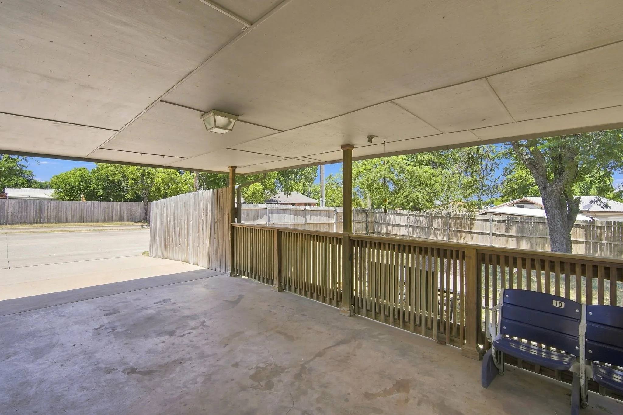 Covered patio overlooking the fenced backyard, ideal for outdoor gatherings.