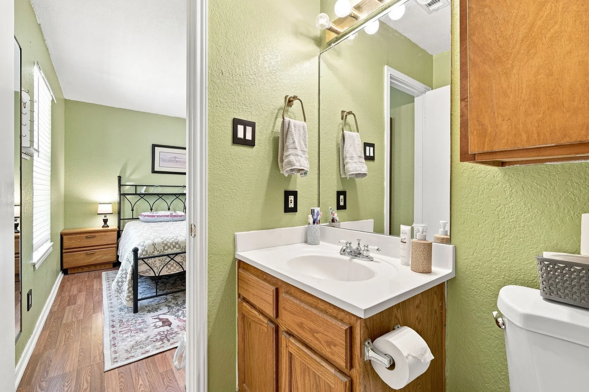 Full bathroom with a vanity and mirror, conveniently located off the adjoining bedroom.