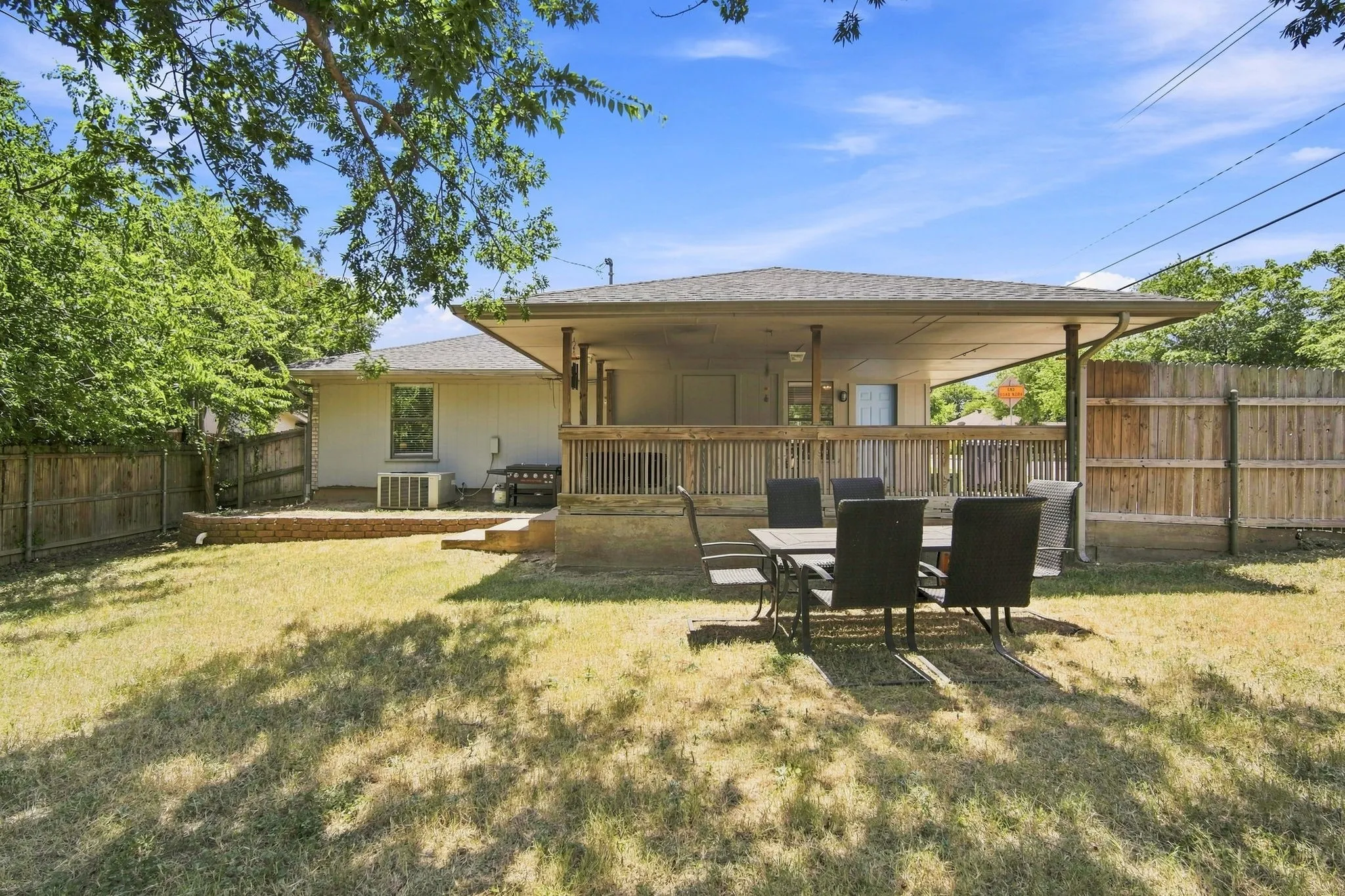 Covered back patio overlooking a large fenced yard, an inviting space to relax or entertain.