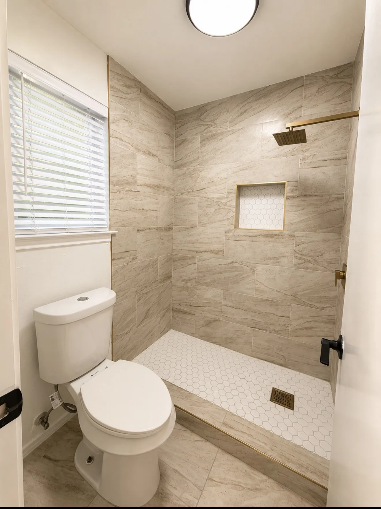 Modern primary bathroom featuring a walk-in shower with linear drain, subway tile surround, and brushed nickel fixtures