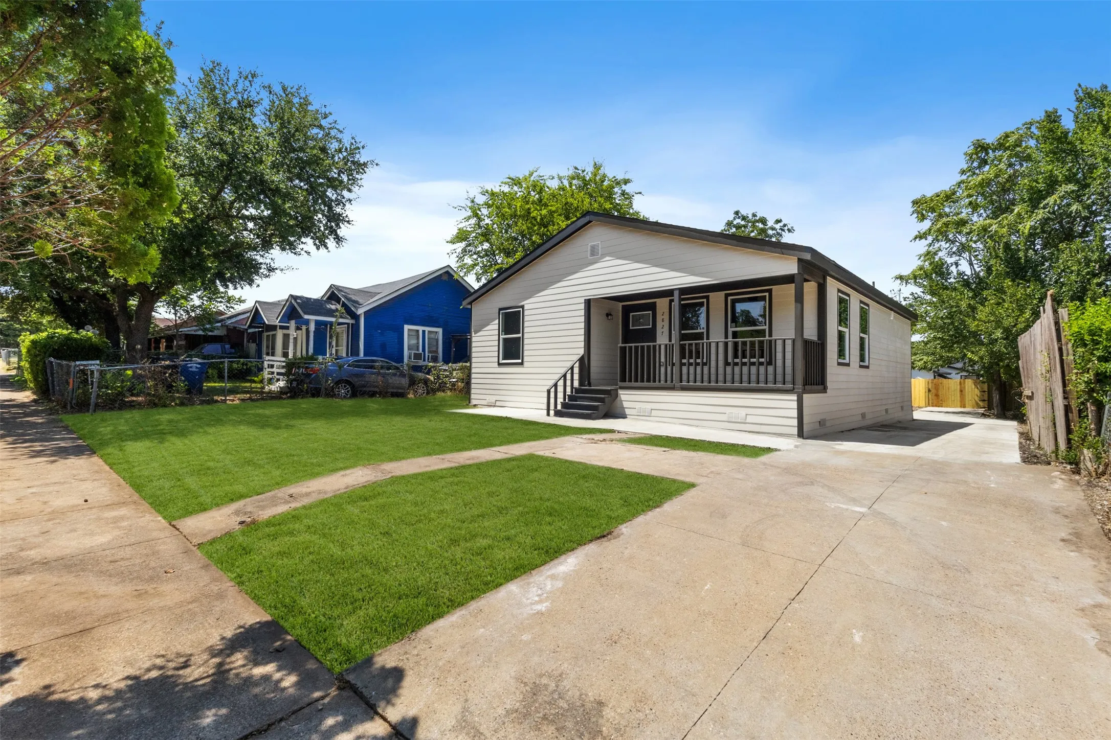 Charming single-story residence featuring a light-colored exterior with covered front porch and black-trimmed windows