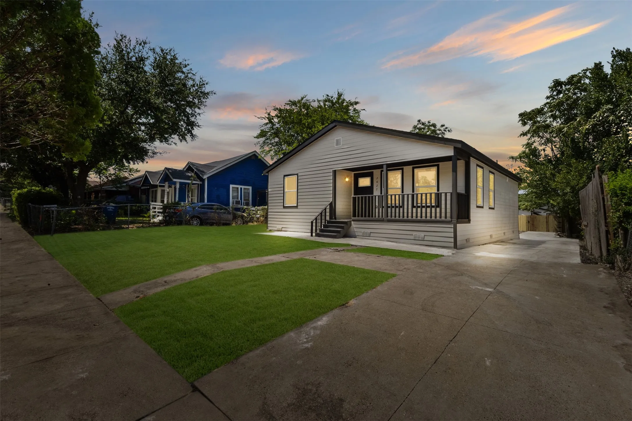 Charming single-story residence featuring a light-colored horizontal siding exterior with a covered front porch and railing