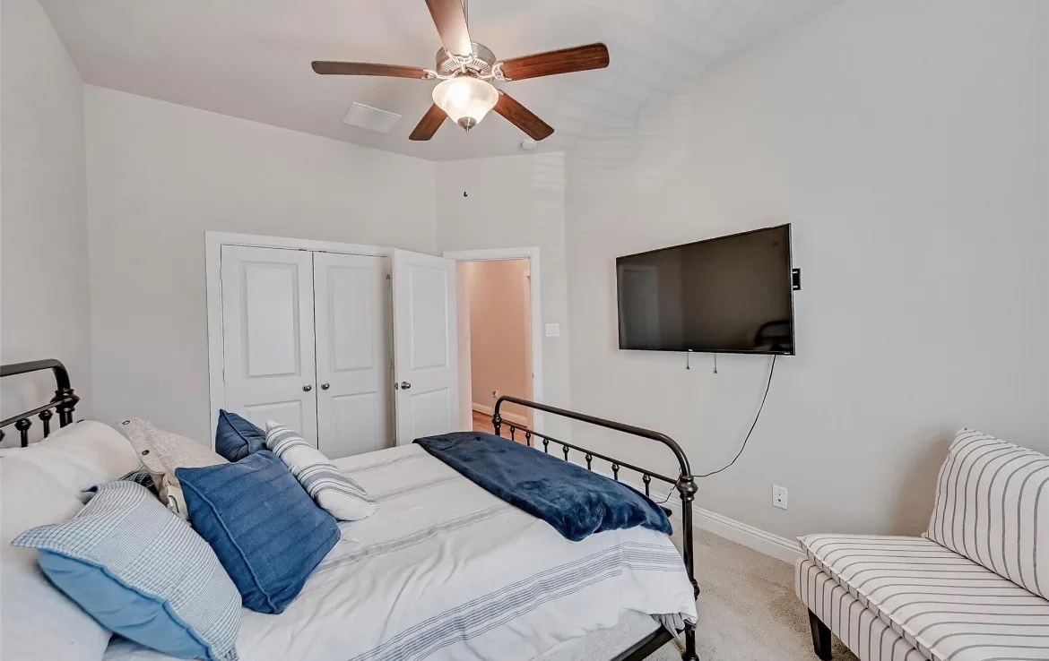 Secondary Bedroom featuring ceiling fan, walk-in closet