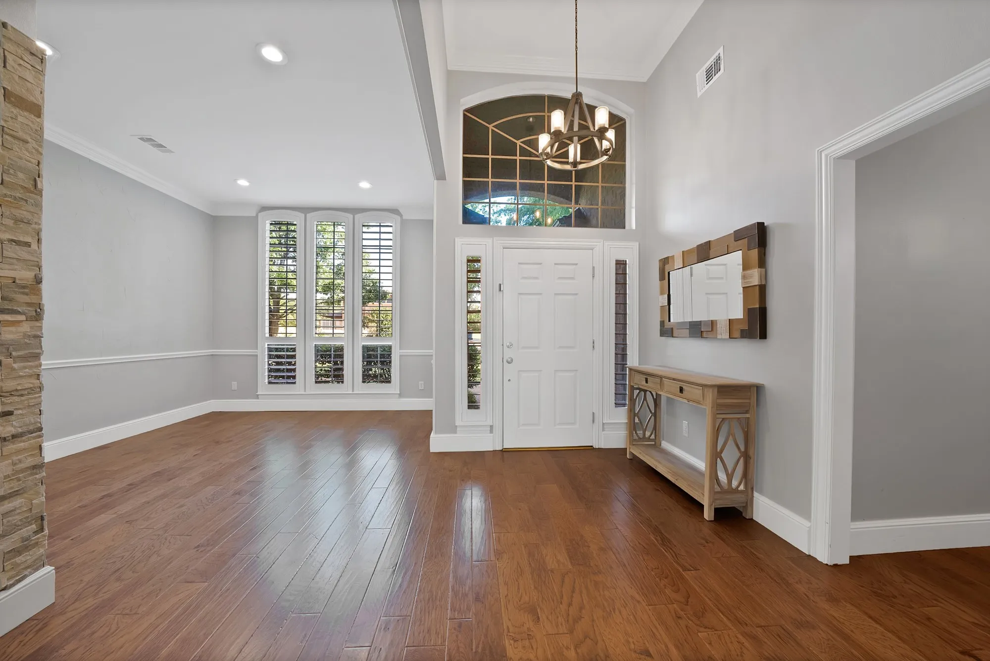 Grand foyer featuring a paneled entry door with an arched transom window and sidelights