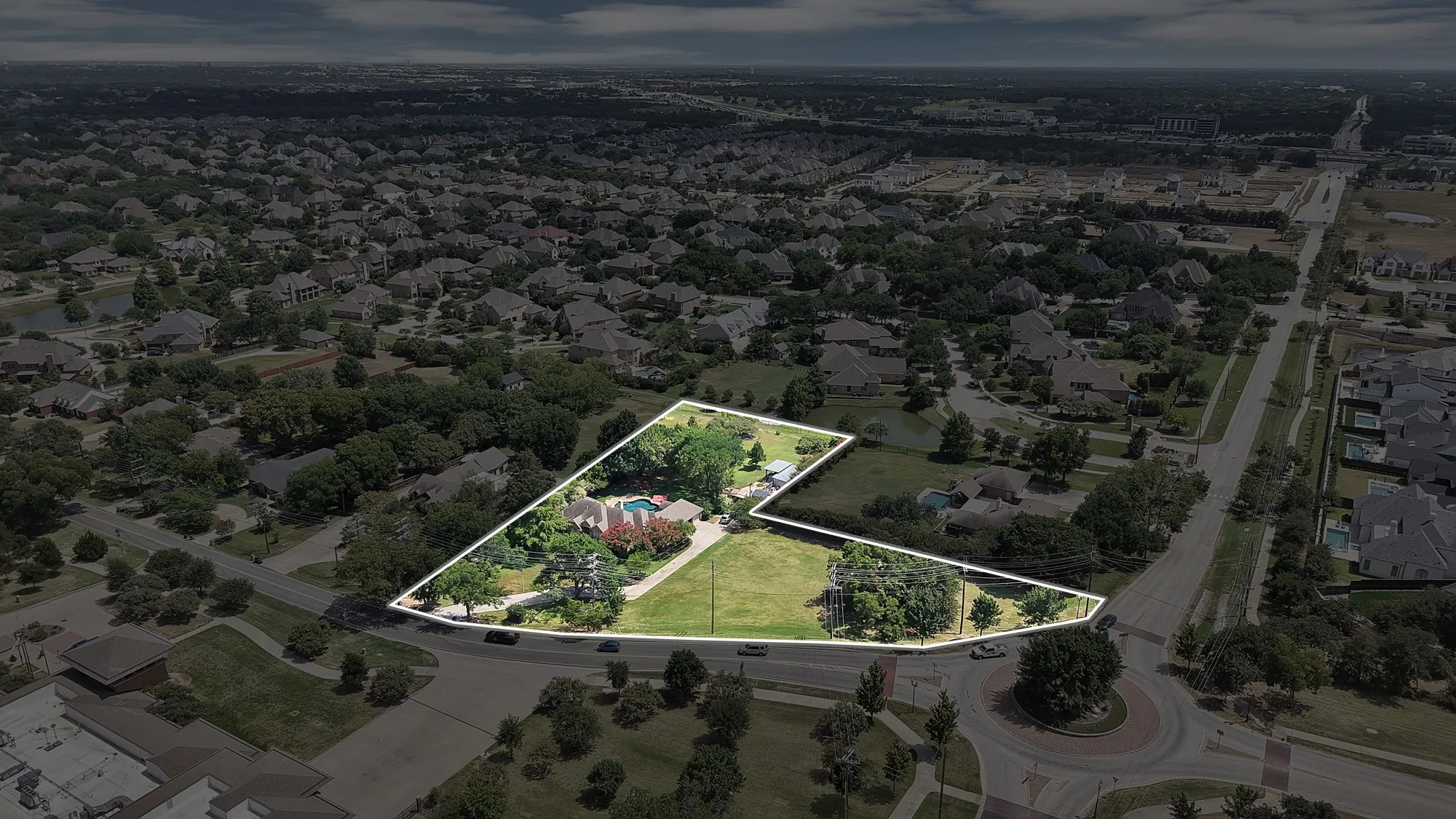 Expansive property featuring a red tile roof, mature landscaping, a swimming pool, and significant green space