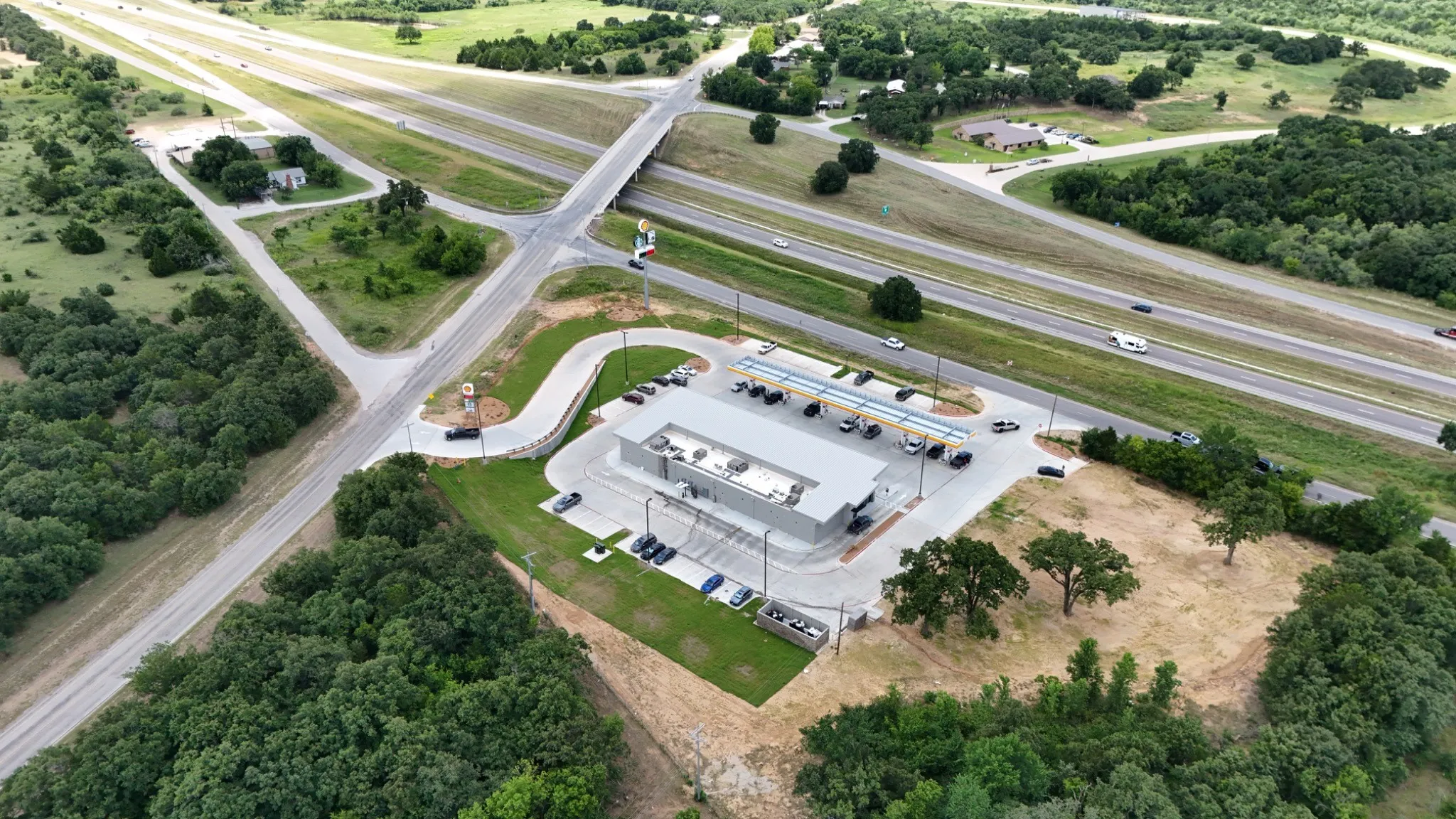 Modern commercial or industrial facility positioned on expansive grounds with mature tree coverage