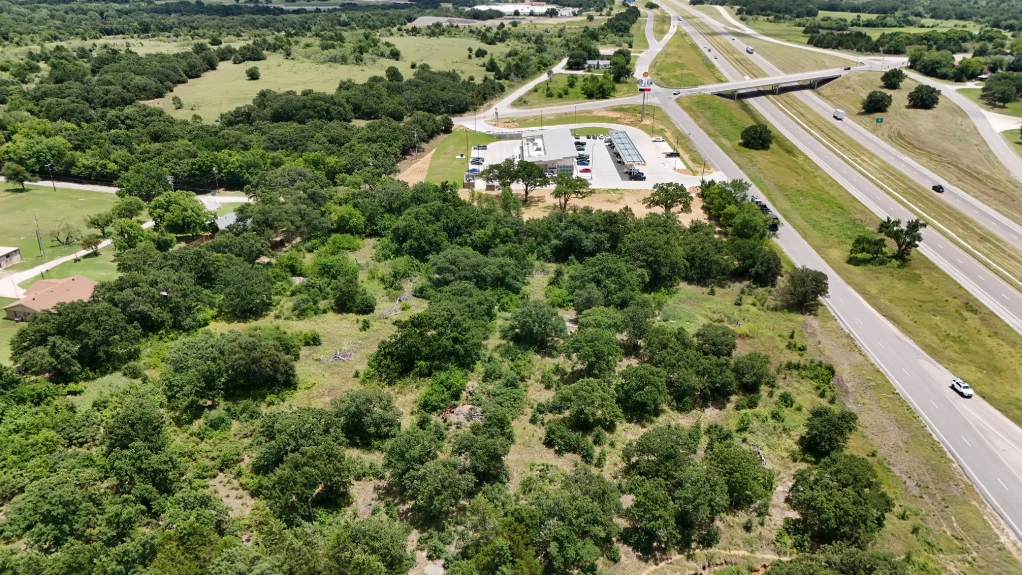 Expansive land parcel featuring dense tree coverage and grassy areas