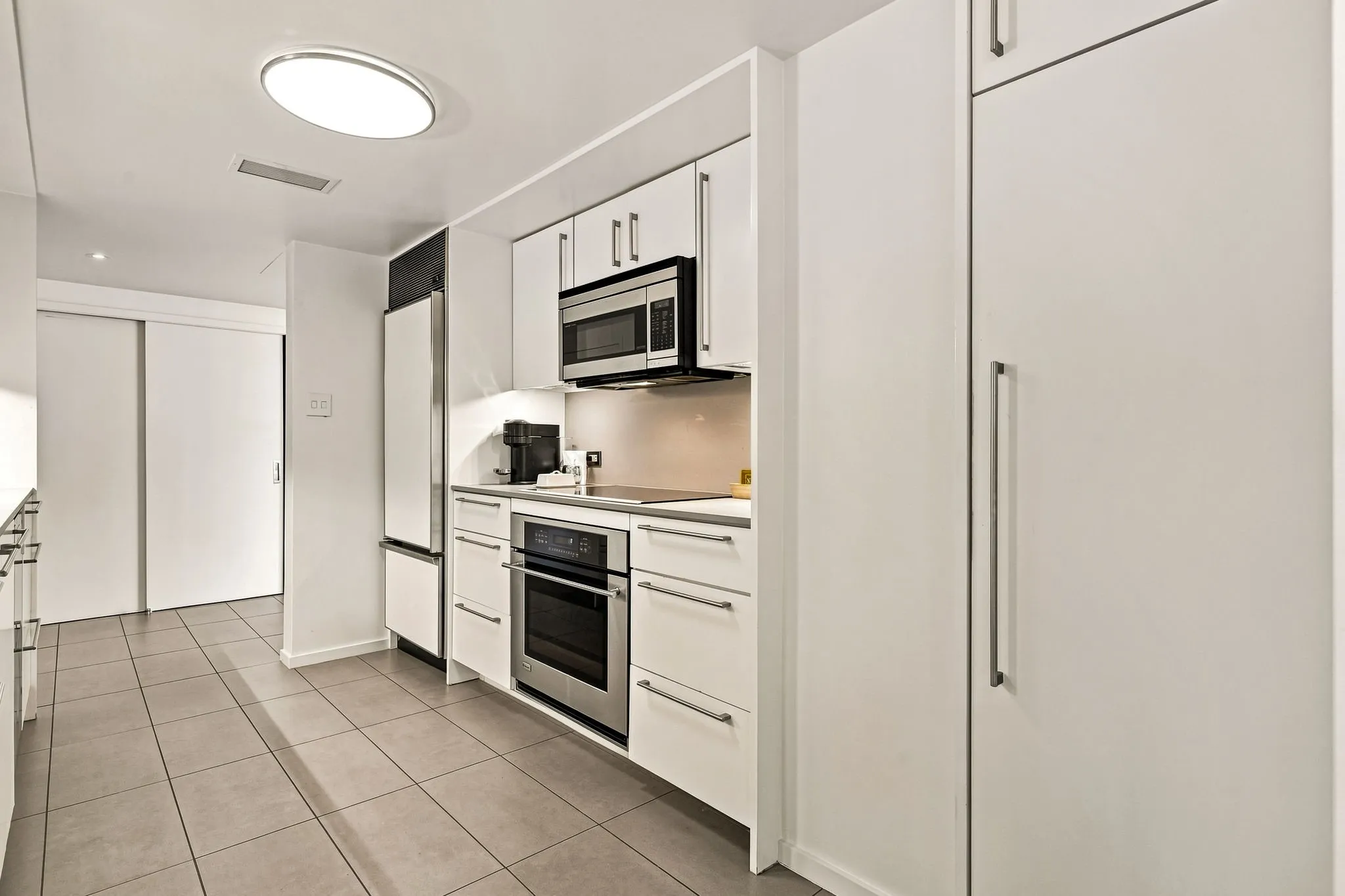Large pantry space on the right, plus under-counter lighting as an added bonus. Laundry and utility closet is shown on the opposite end of the kitchen.