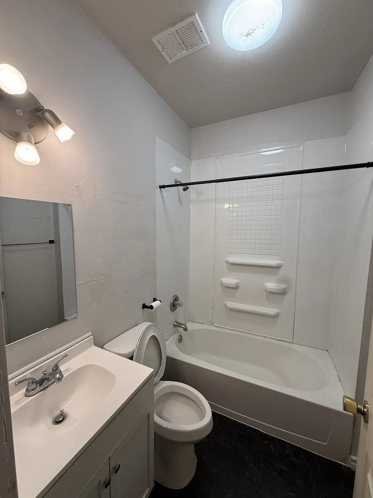 Bathroom featuring a white vanity with integrated sink, chrome faucet, and mirrored medicine cabinet