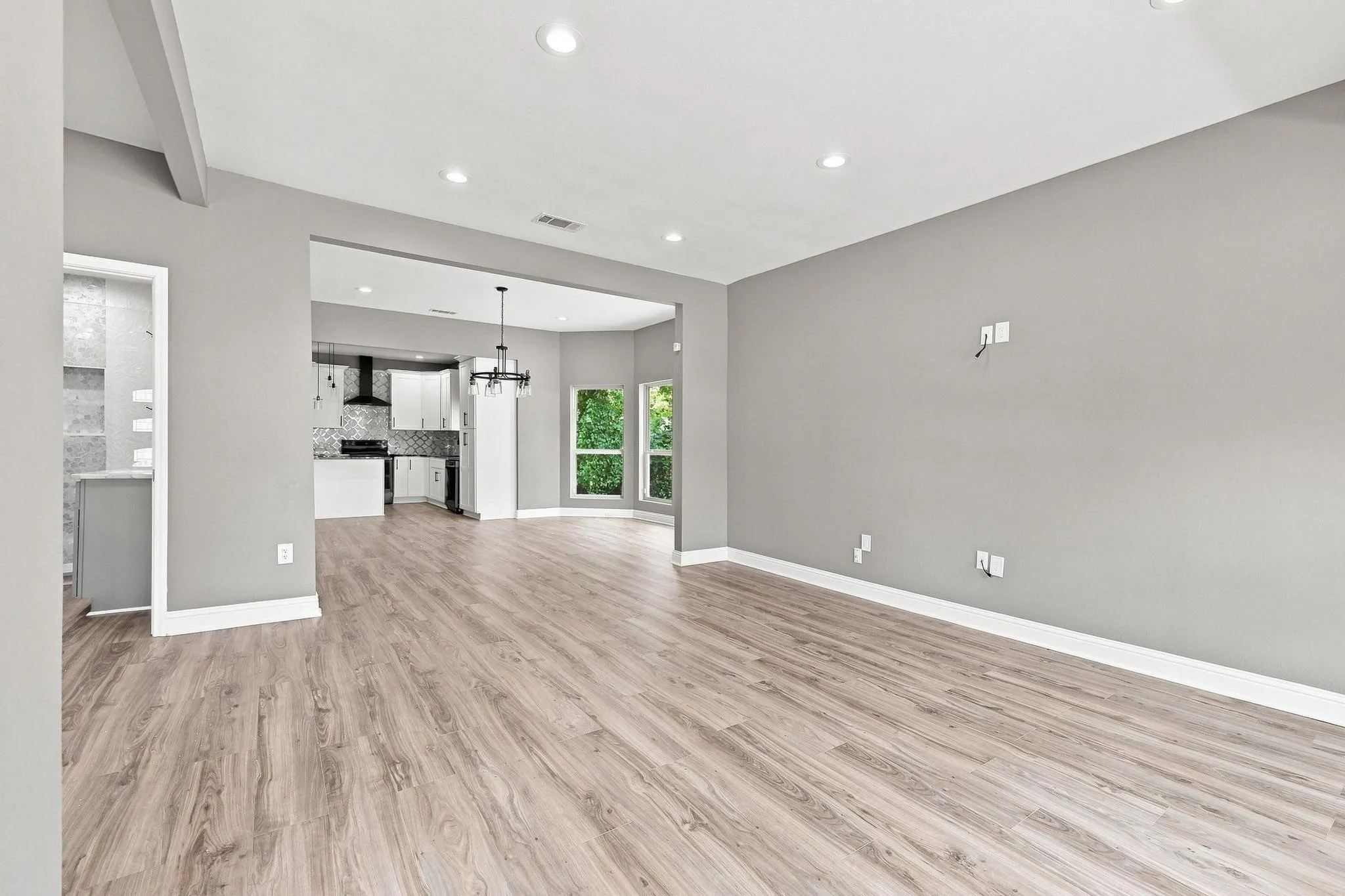 Spacious living area featuring wood-finish flooring, recessed lighting, and a neutral wall palette