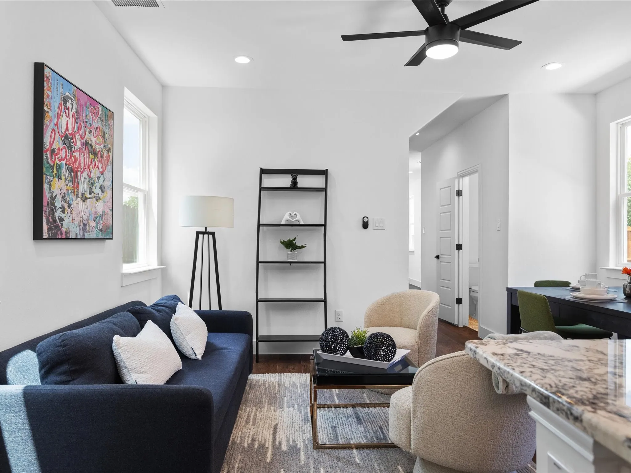 Open-concept living area featuring hardwood flooring, recessed lighting, a modern ceiling fan, and white trim