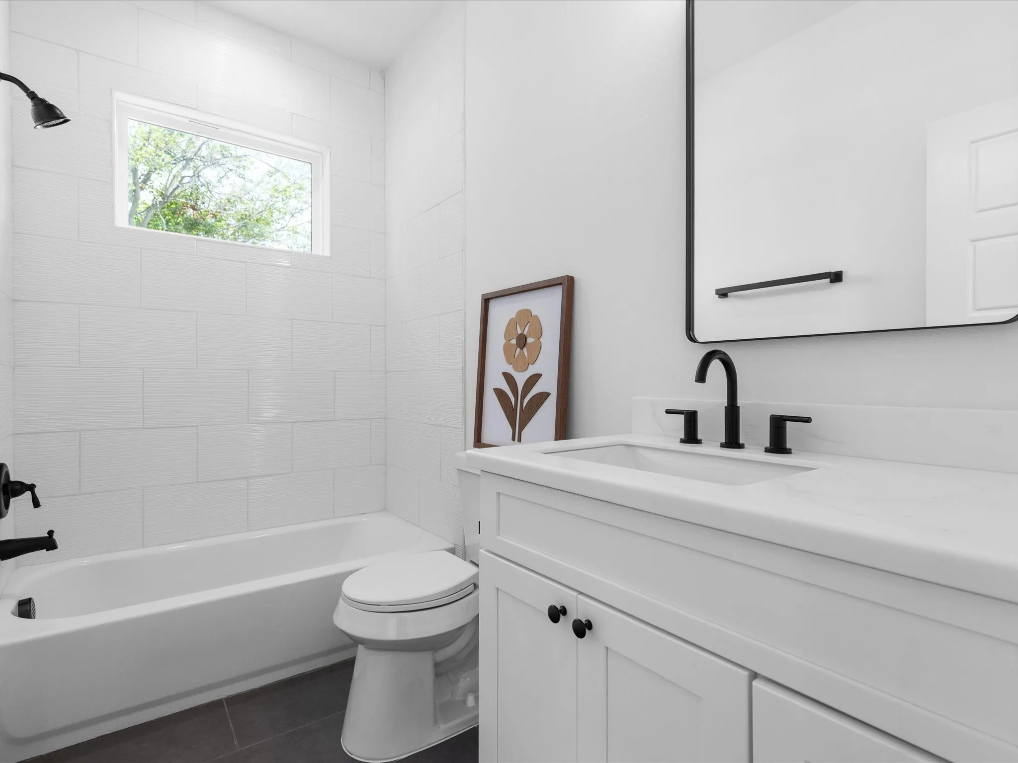 Bathroom featuring a white vanity with panel cabinetry and black hardware