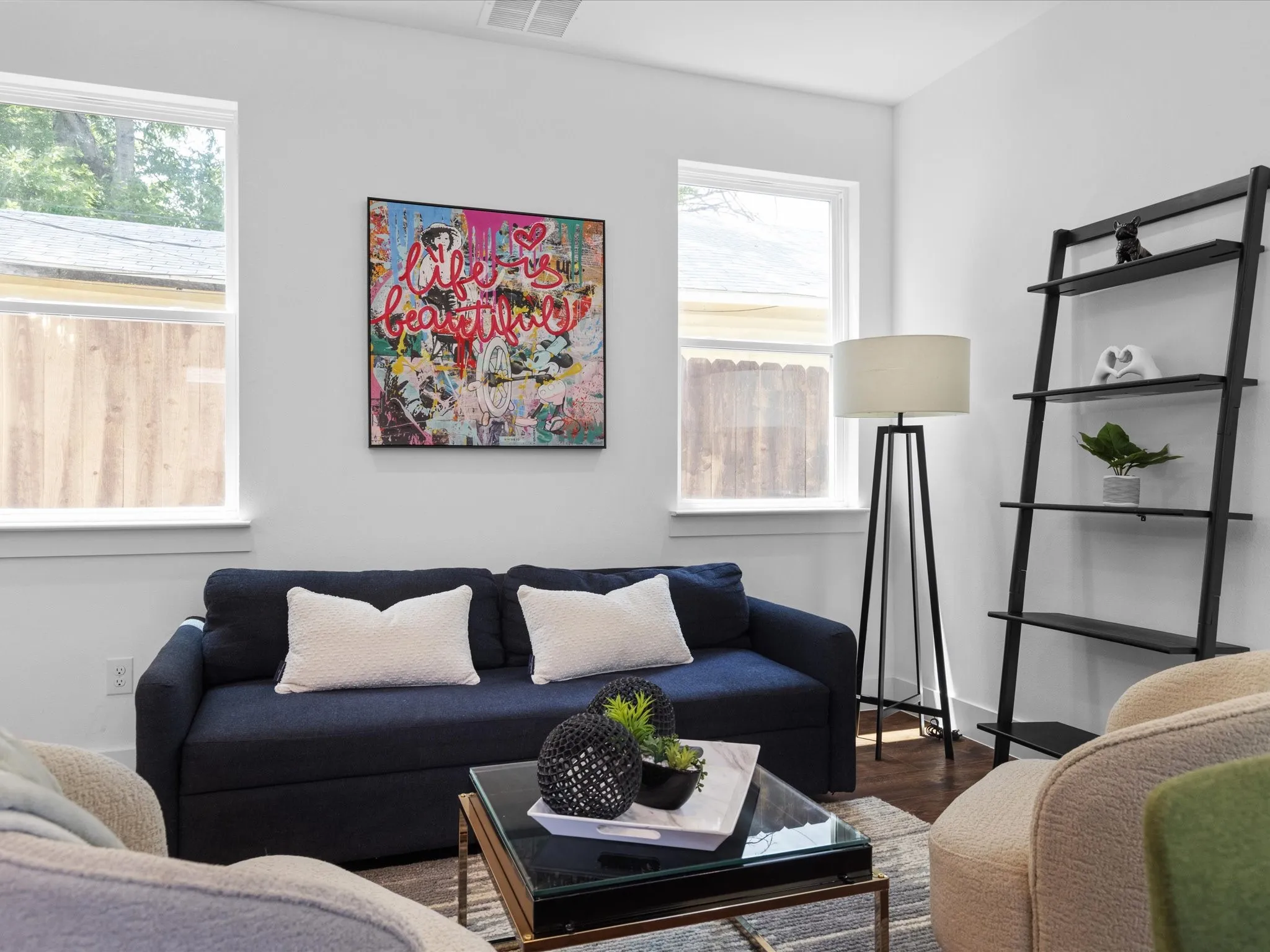 Living area featuring wood-finish flooring, white walls, and multiple windows