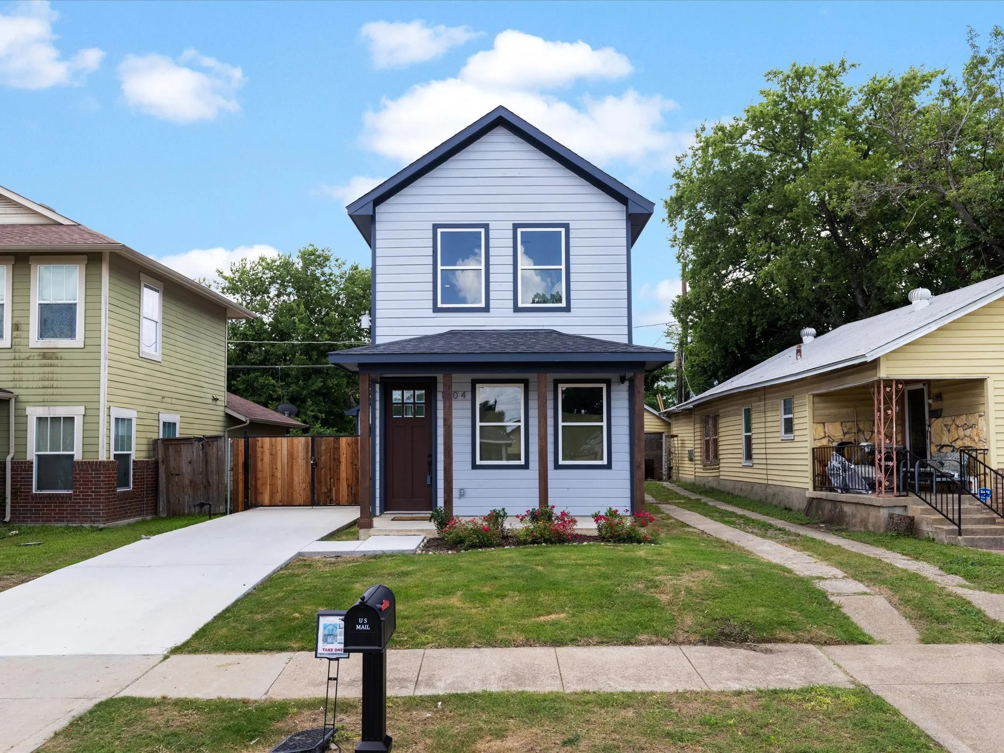 Two-story residence featuring light blue siding with dark trim accents and a dark roof
