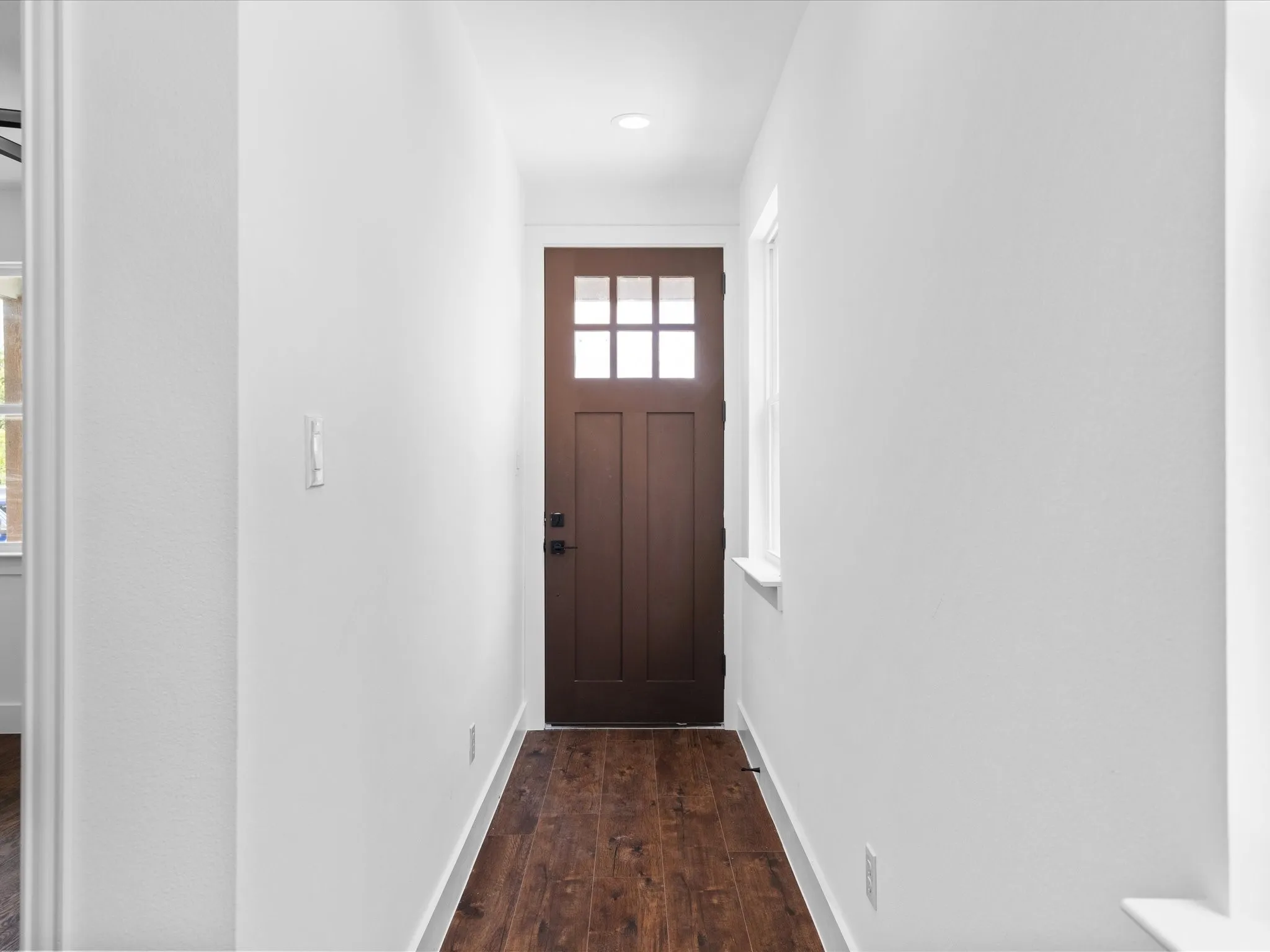 Entryway featuring a dark wood-finish door with glass panes, recessed lighting, and rich wood-finish flooring