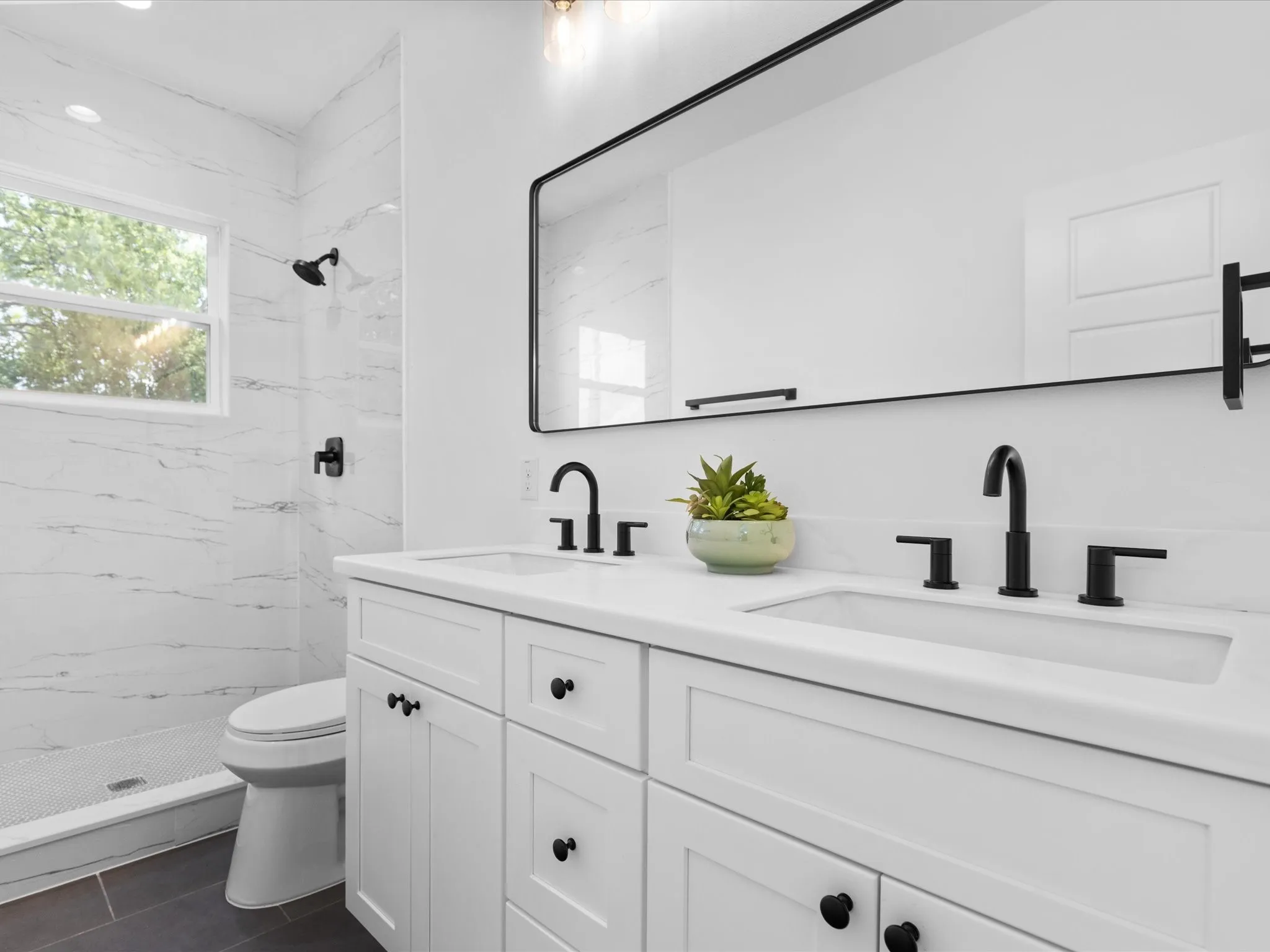 Double vanity with white shaker cabinetry, integrated sinks, and black hardware
