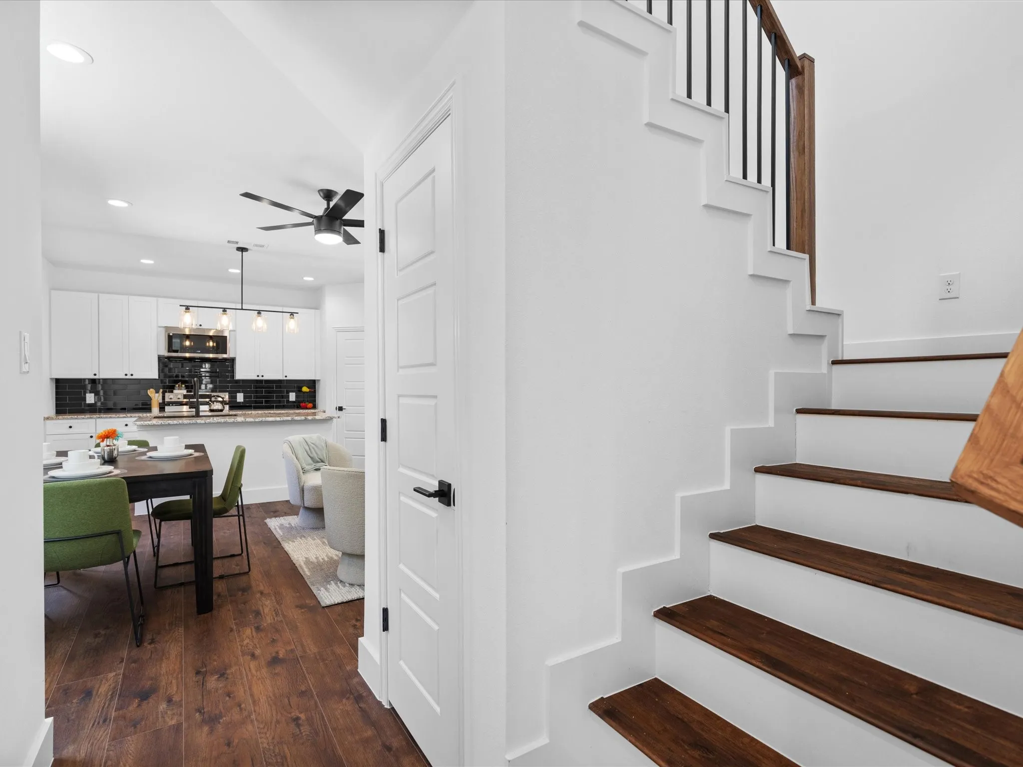 Staircase featuring dark wood-finish treads and white risers with a contrasting black spindle railing