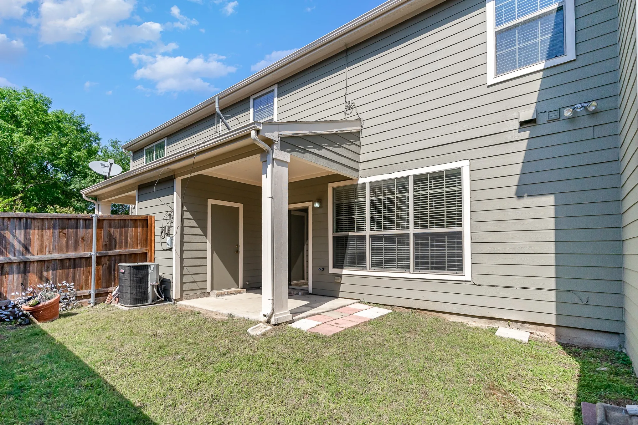 Rear view of house with a patio, a lawn, and central air condition unit