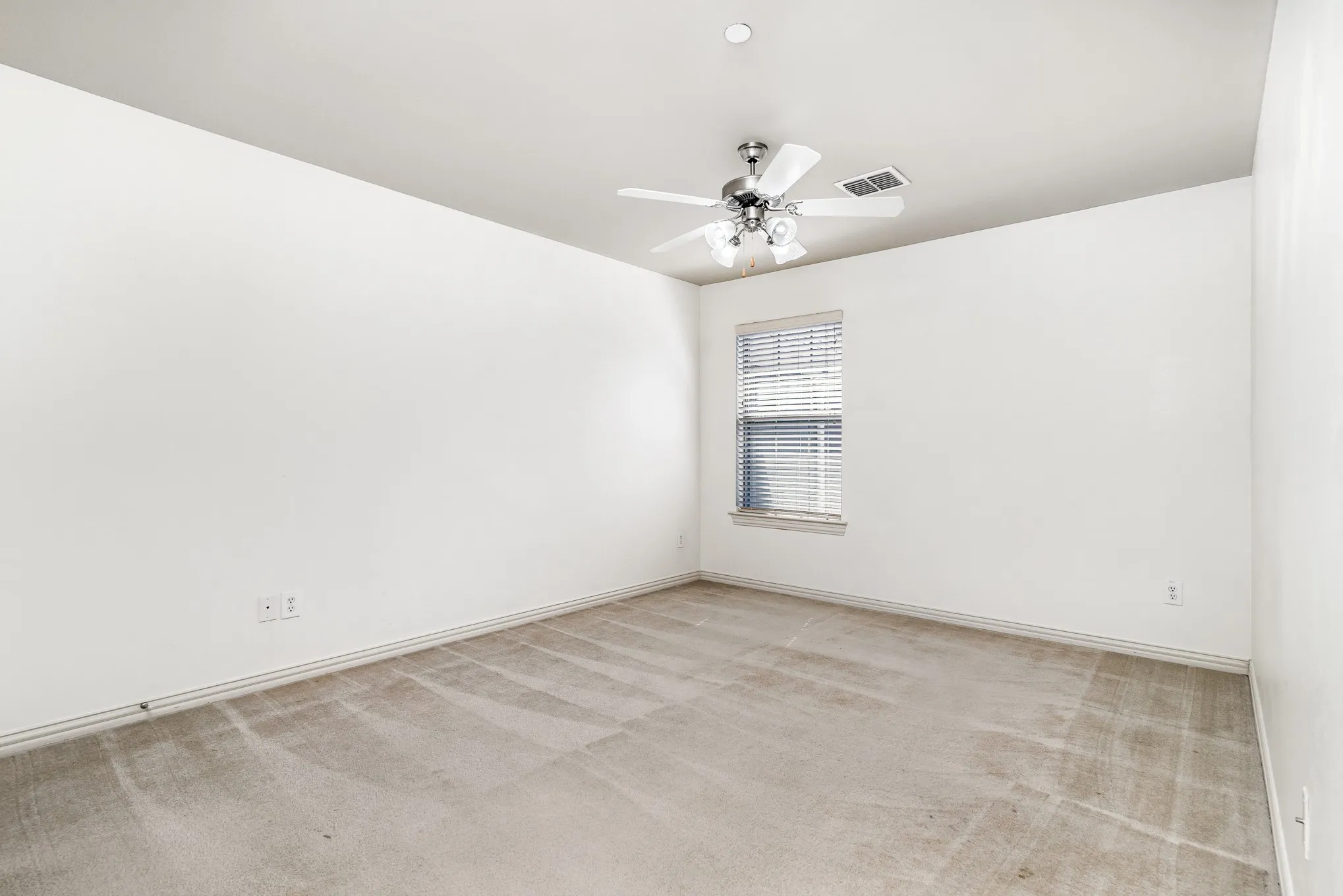 Carpeted empty room with ceiling fan