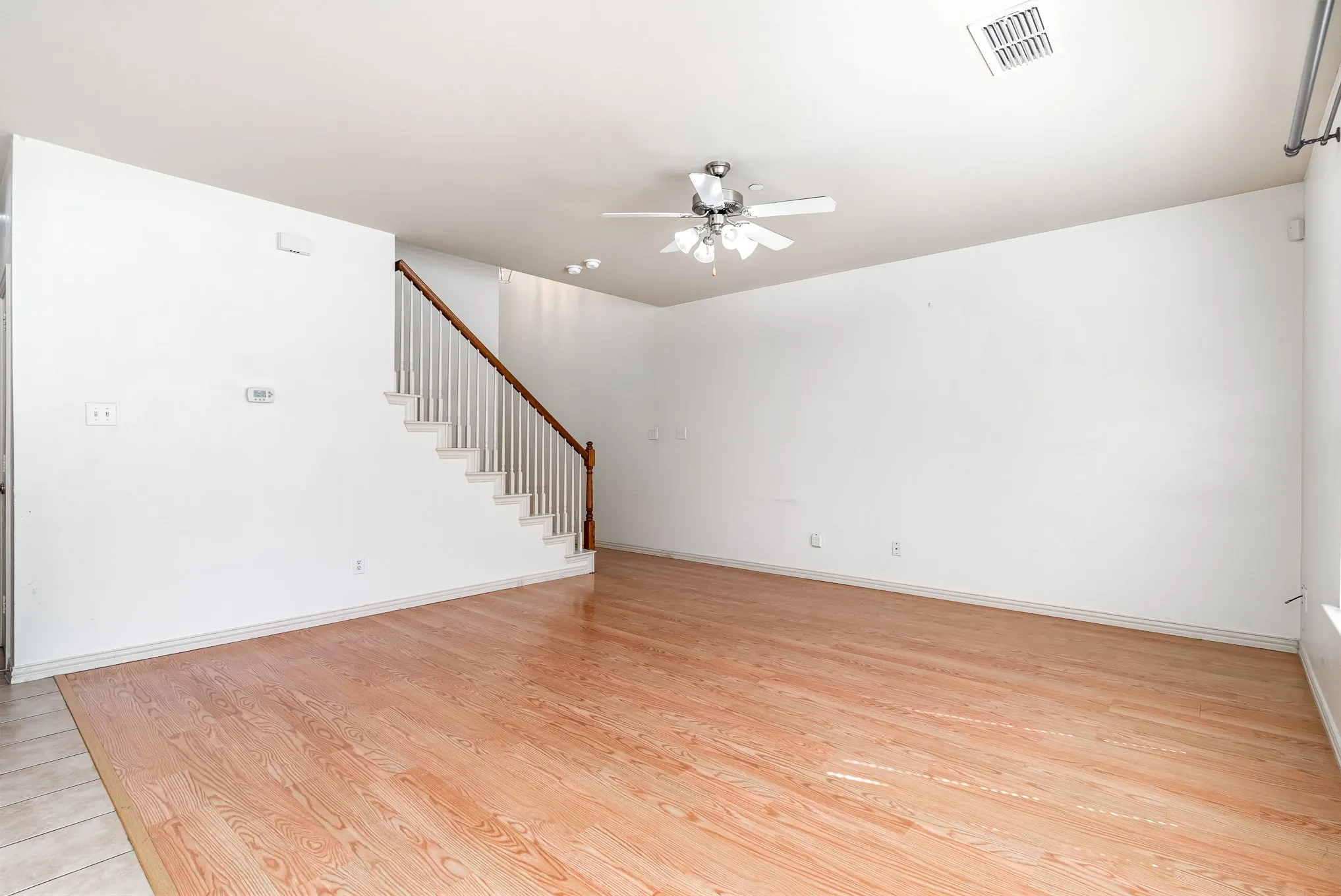 Unfurnished living room with ceiling fan and light wood-type flooring