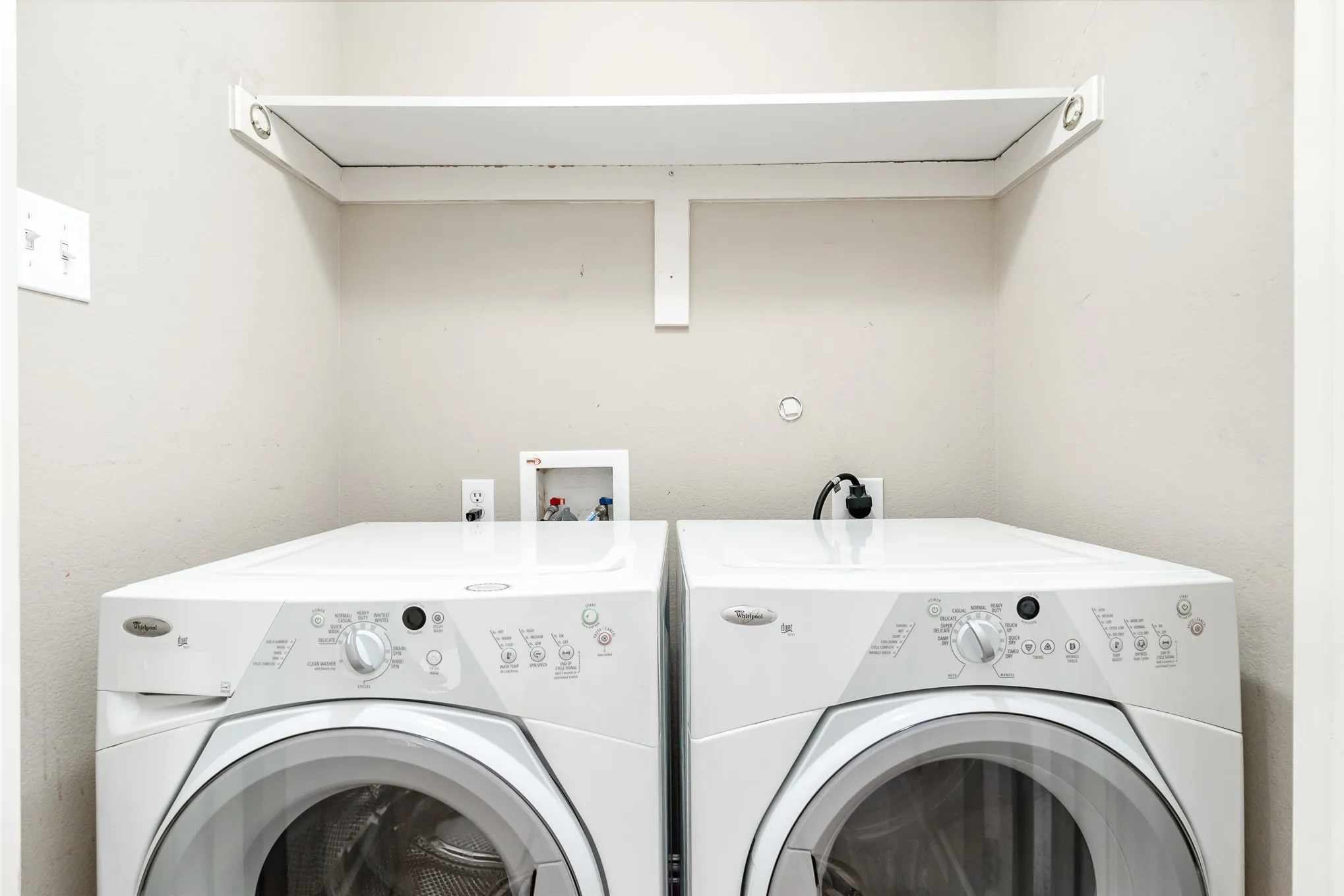 Clothes washing area featuring independent washer and dryer, hookup for an electric dryer, and hookup for a washing machine