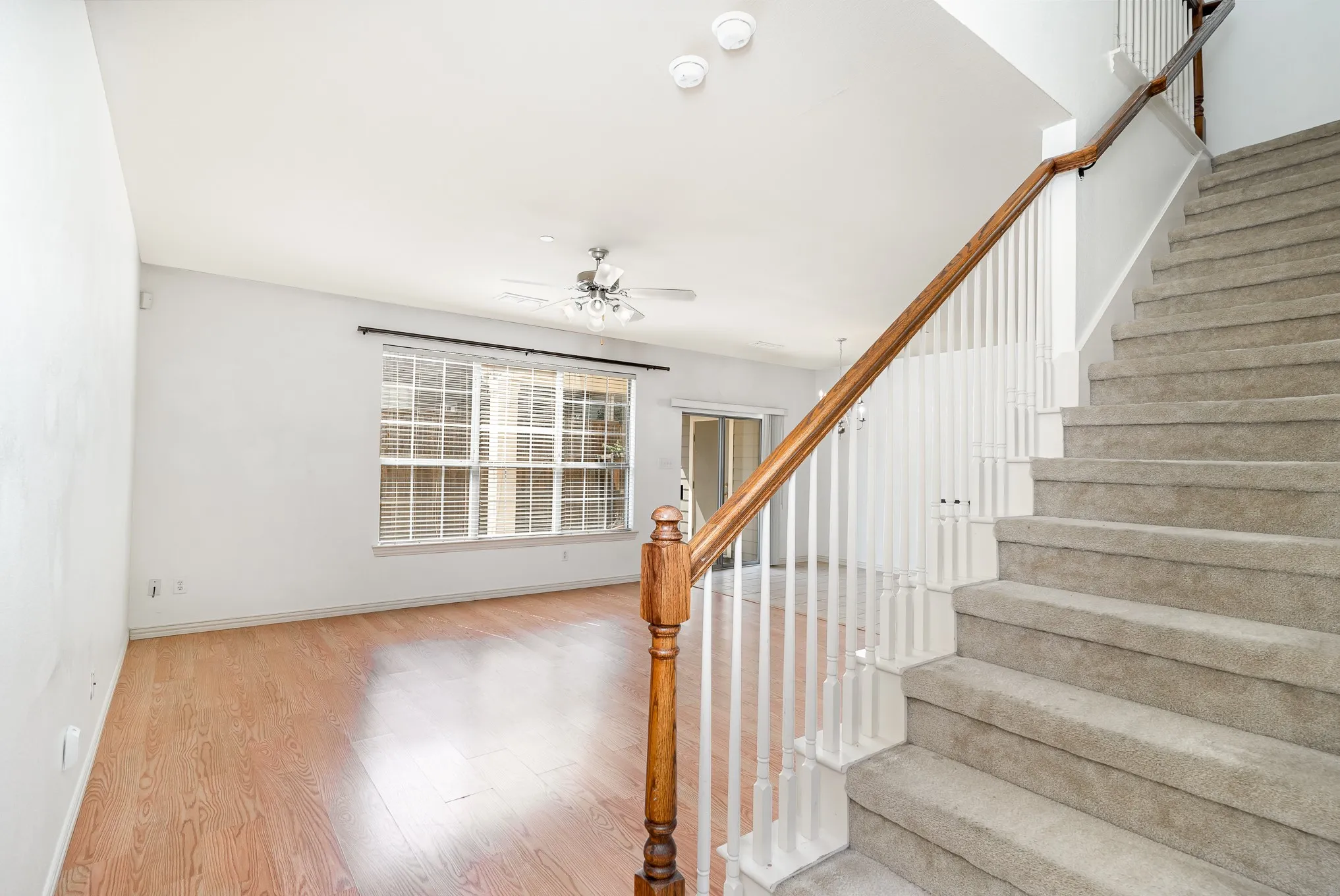 Stairs with ceiling fan and light hardwood / wood-style flooring