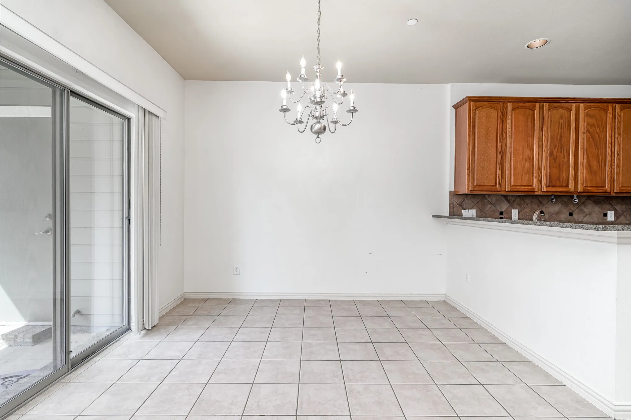 Unfurnished dining area with an inviting chandelier and light tile flooring