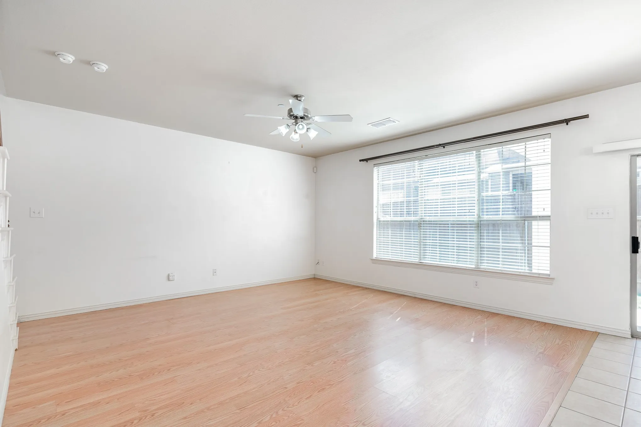 Empty room with ceiling fan and light hardwood / wood-style flooring