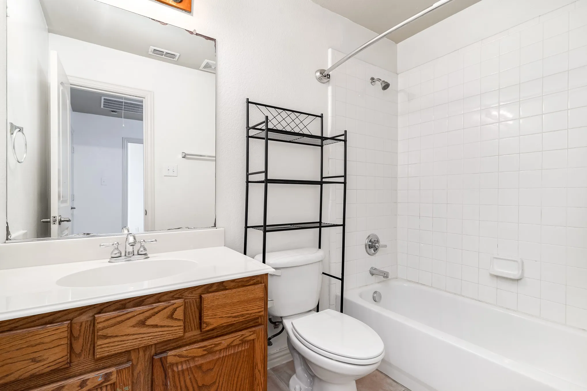 Full bathroom with tiled shower / bath, toilet, and vanity with extensive cabinet space