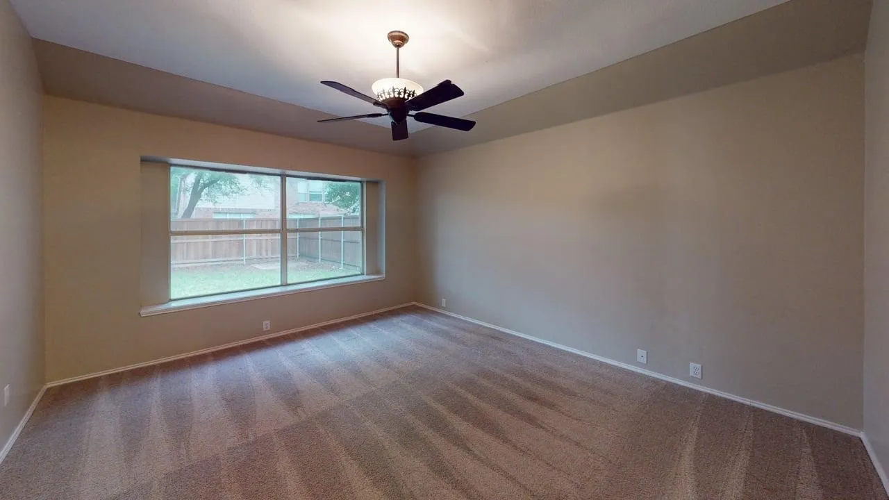 Spacious bedroom featuring wood-finish flooring, neutral wall finishes, and abundant natural light from large dual-pane windows
