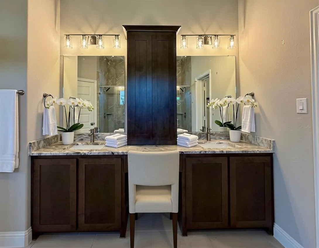 Dual vanity with custom cabinet between them with outlet that is perfect for storing hair dryer and flat iron as well as hair products, creams, make up, and other neccessities