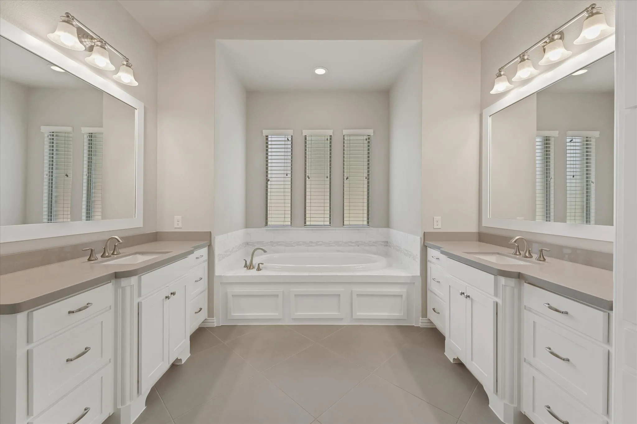 The primary bedroom is located on the first floor and has a perfect split floorplan with the other bedroom in the mother in law wing. Both feature an ensute bath. The main primary bath is huge! It features a nice tile walk in shower, a large garden soaking tub, and separte vanities as well as a gigantic walk in closet.