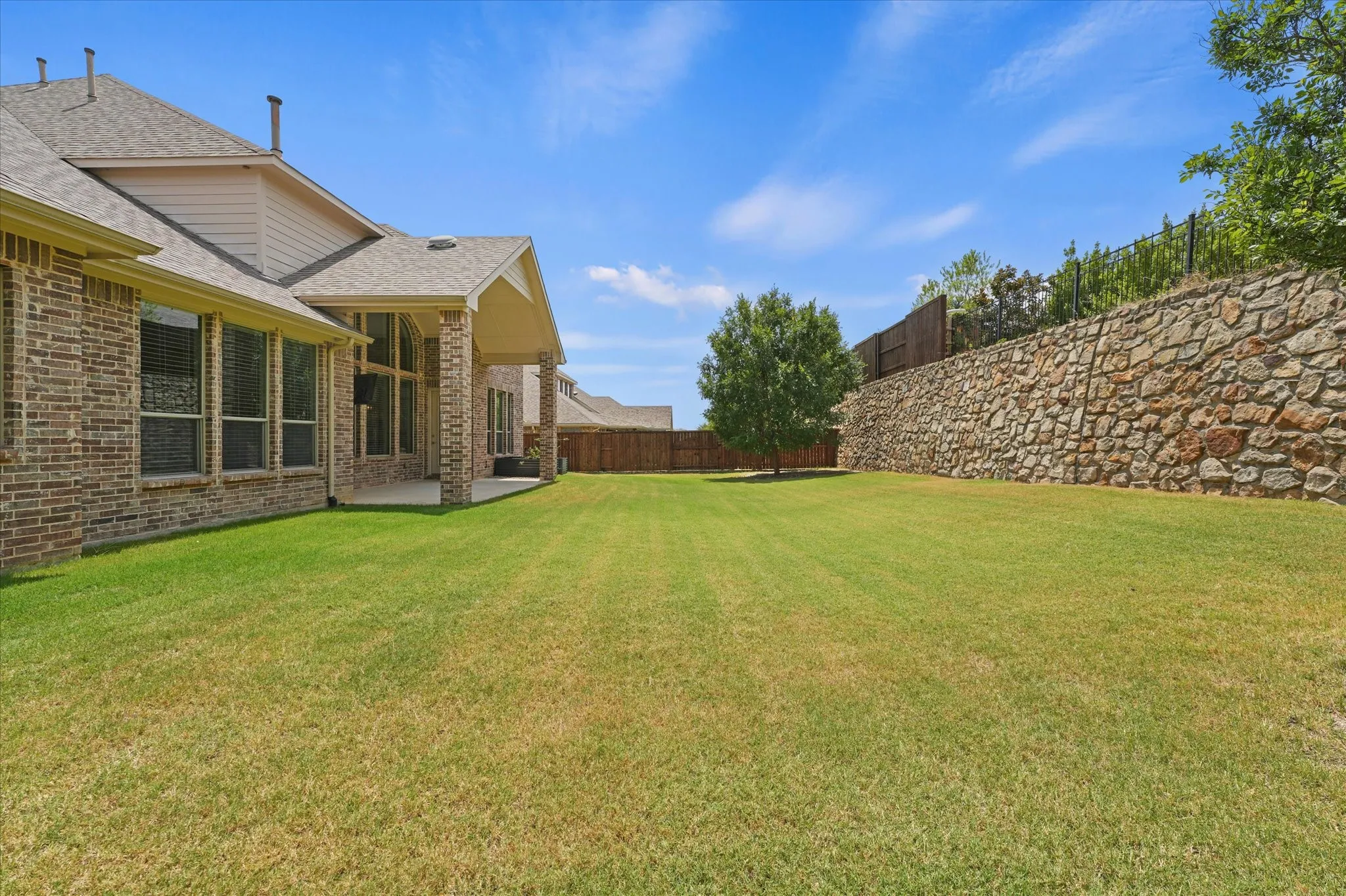 This yard is huge as the home sits on over a quarter acer lot! There is room here for endless ideas like a great pool and more. The stone wall and stained fence are in great condition. The yard is well maintained. The backyard backs up to a greenbelt for extra quiet and privacy.
