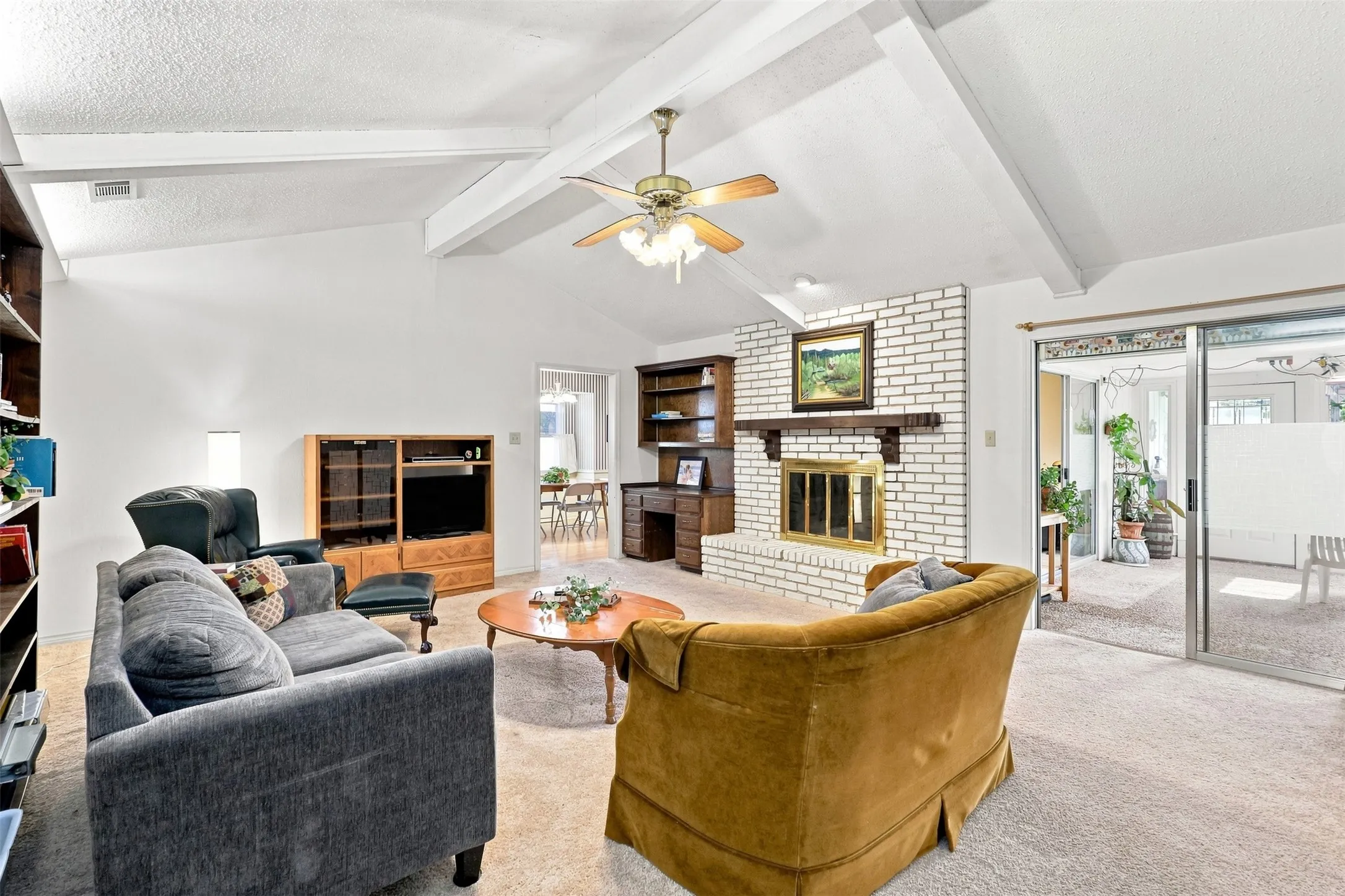 Main living area with high ceilings and wood beams.