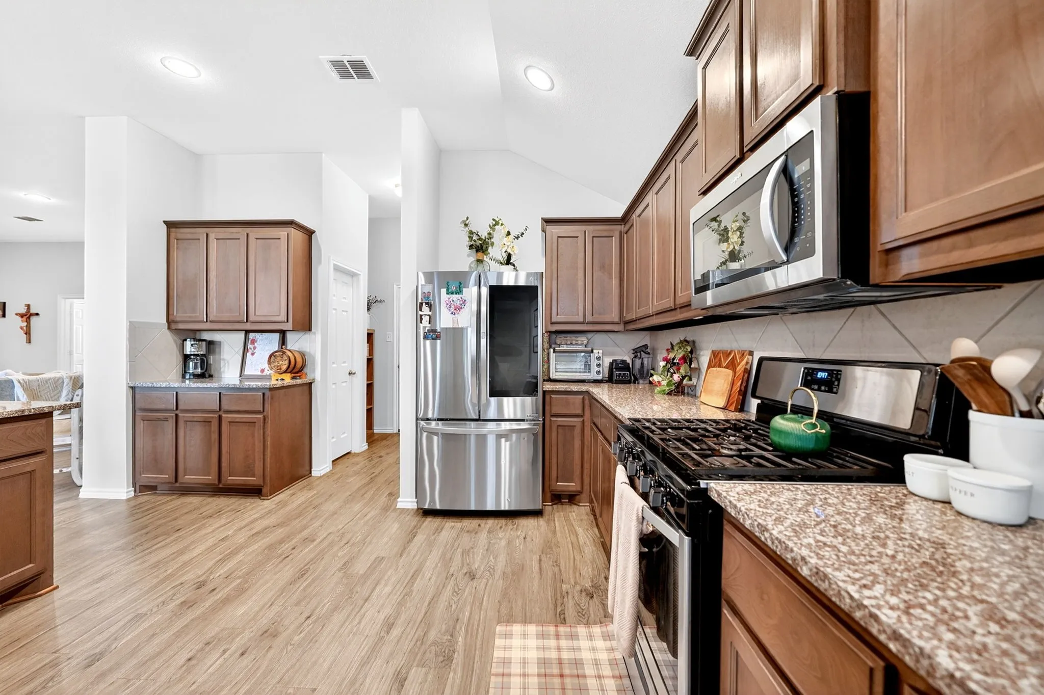 Kitchen featuring wood-finish flooring, recessed lighting, and vaulted ceilings