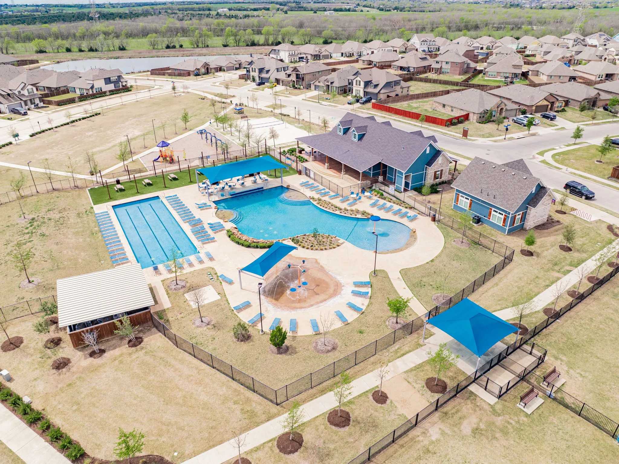 Community pool area featuring a lap pool, a freeform pool, and a splash pad