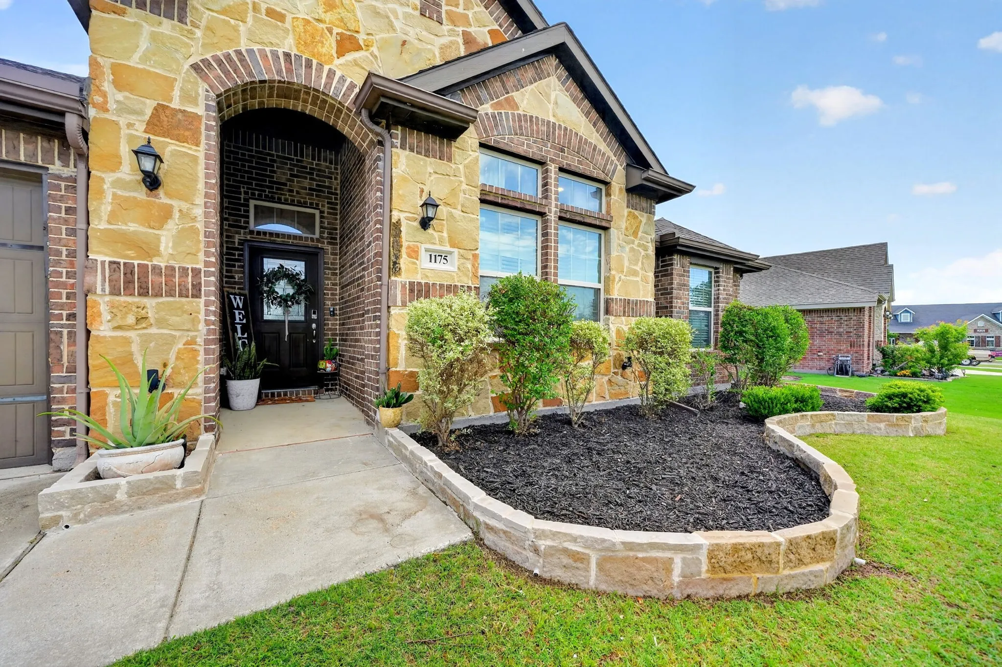 Stone and brick exterior with arched entryway and multiple windows