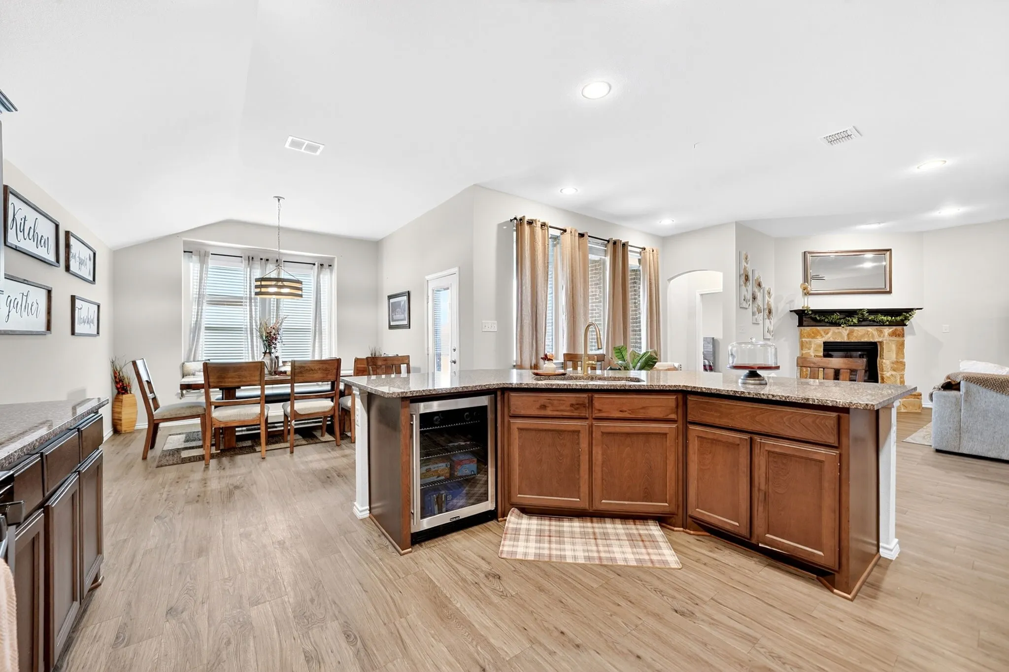Spacious kitchen island featuring a granite countertop, undermount sink, and integrated beverage cooler