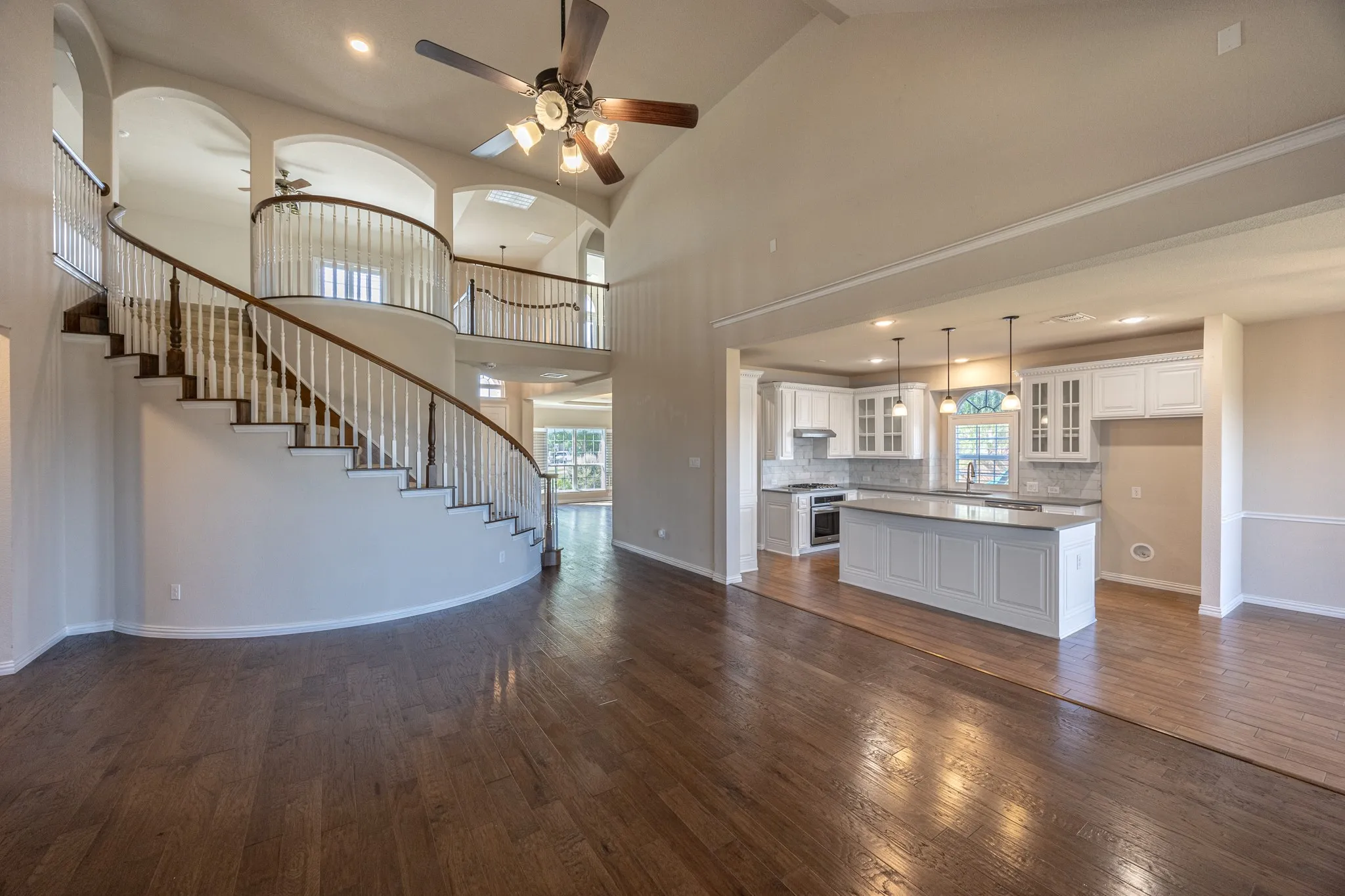 Grand foyer with a curved staircase, hardwood flooring, and a two-story ceiling