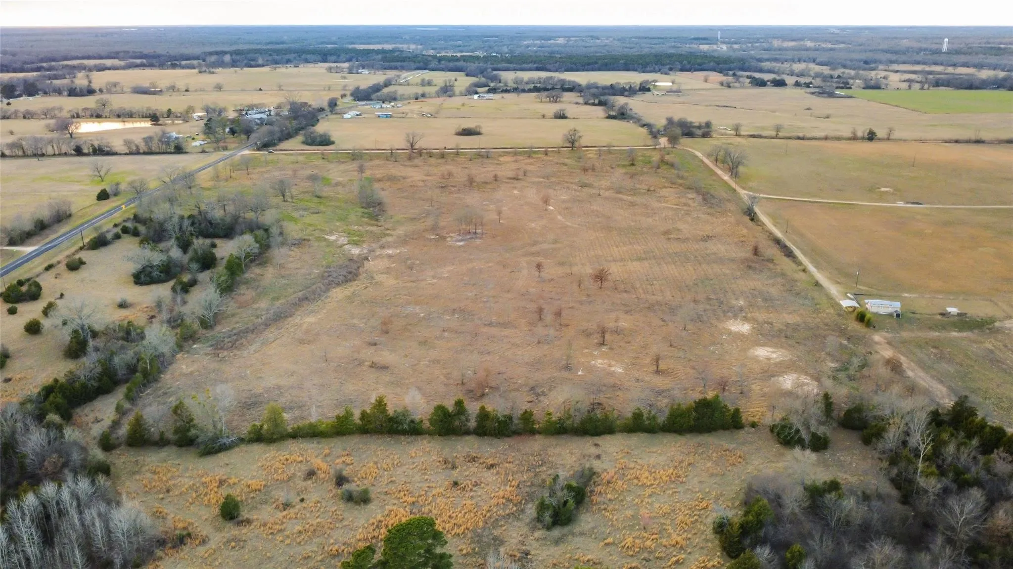 Expansive undeveloped land featuring a mix of open fields and scattered trees