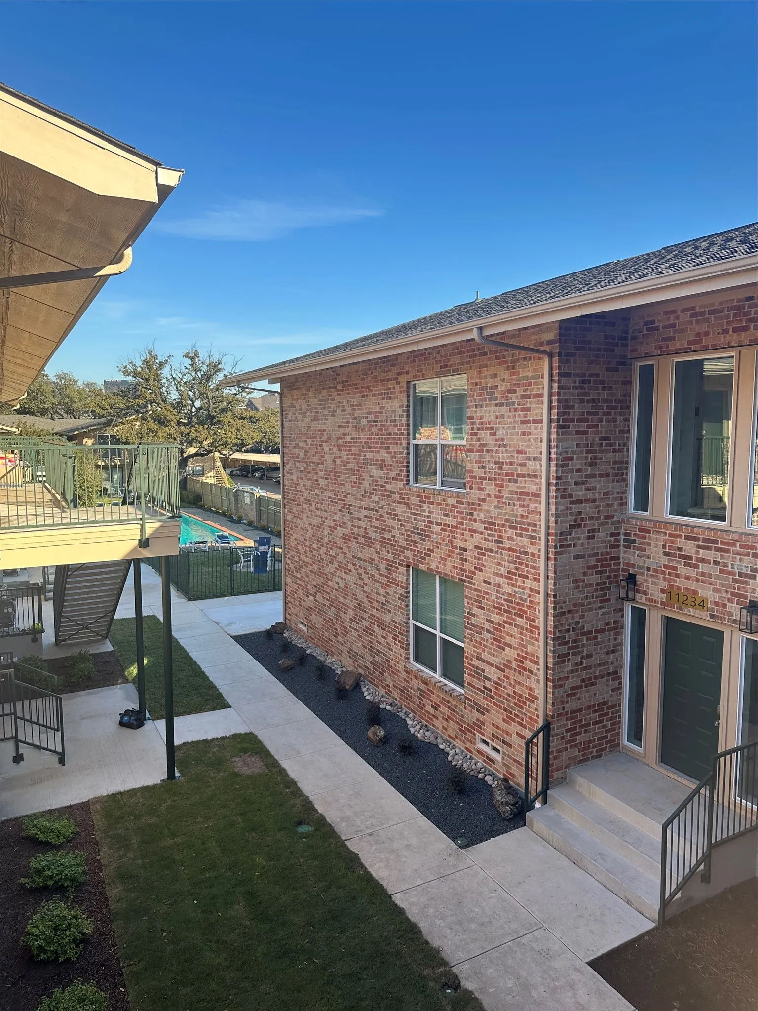 Brick exterior featuring an entry with concrete steps and black metal railings