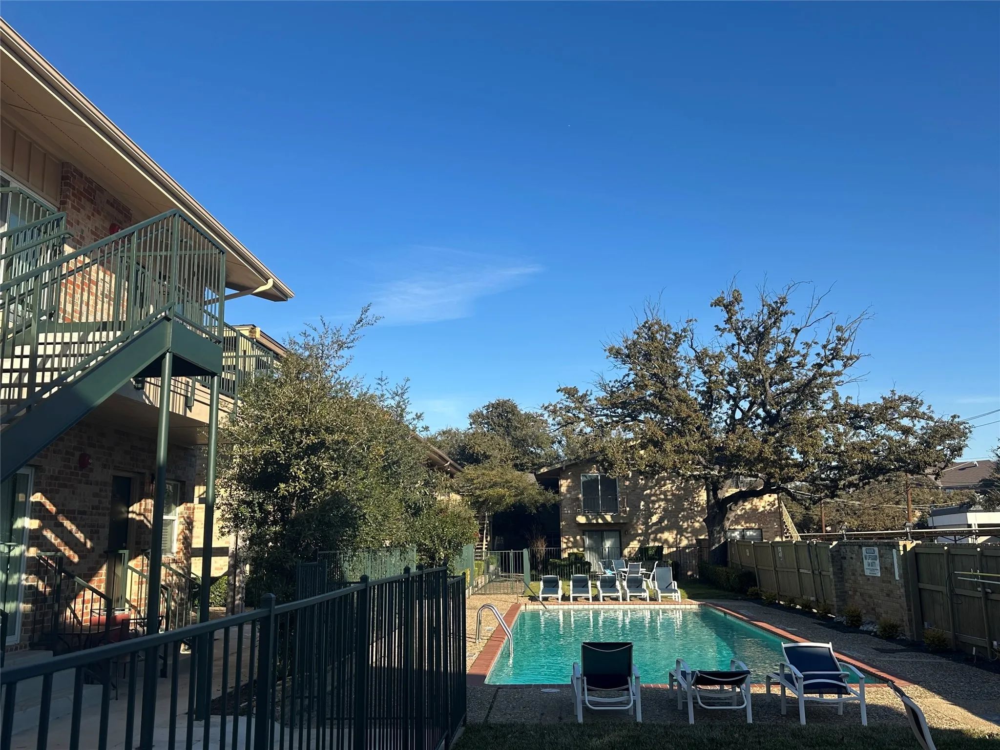 Outdoor swimming pool featuring a concrete deck and multiple lounge chairs