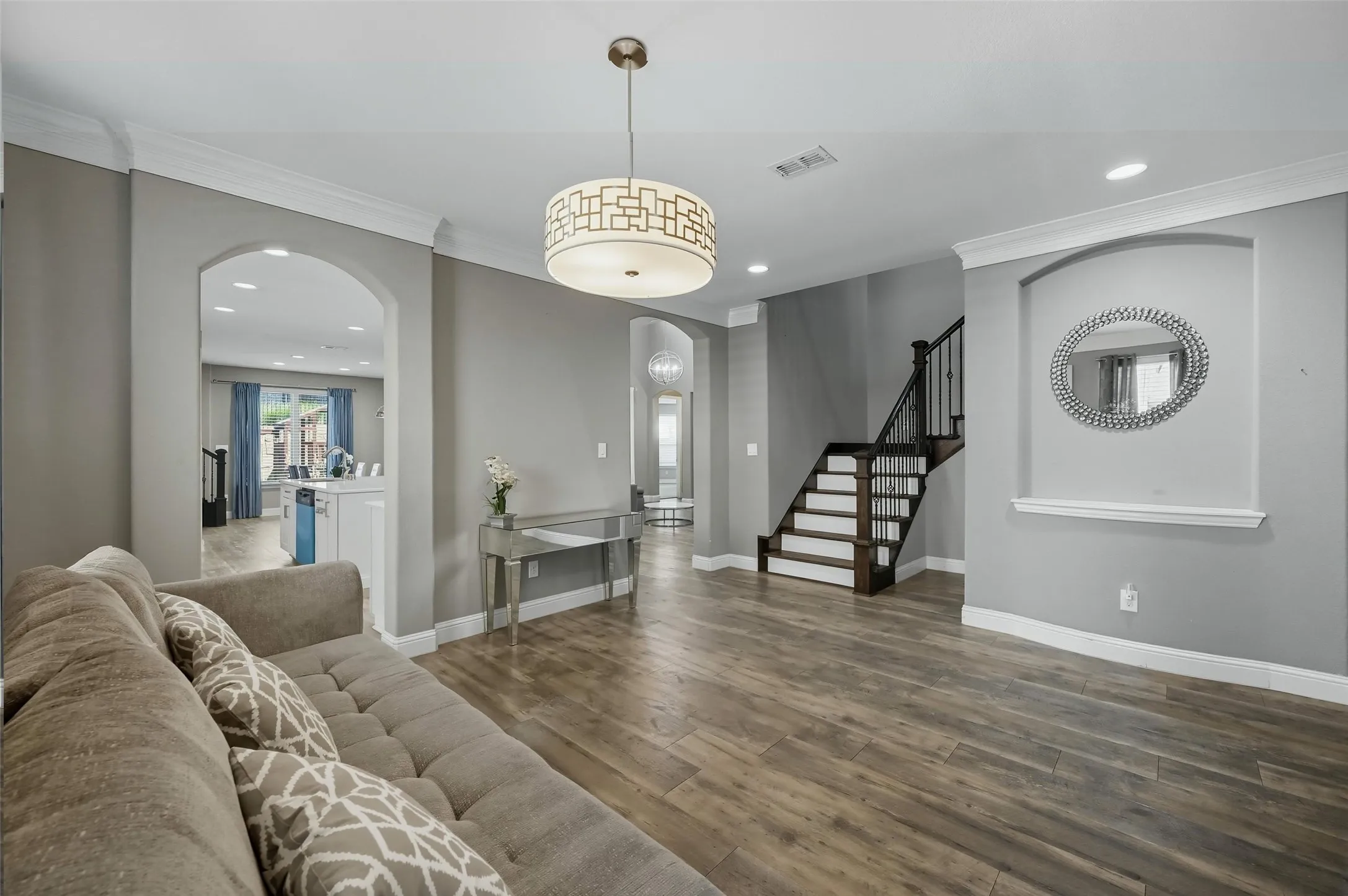 Spacious living area featuring wood-finish flooring and a decorative chandelier